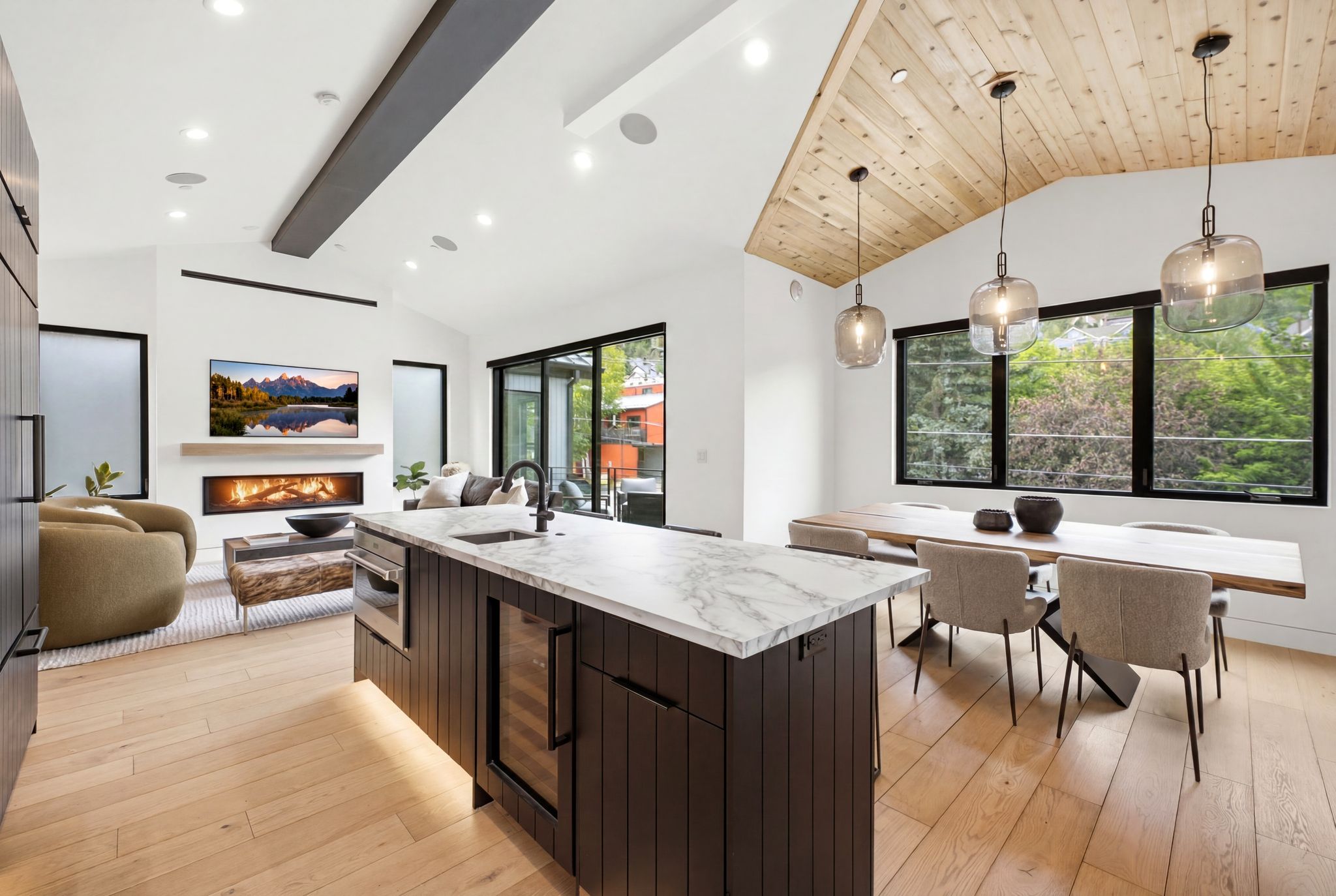 Open-concept living space featuring a central kitchen island with a stone countertop, an integrated beverage cooler, and a built-in microwave