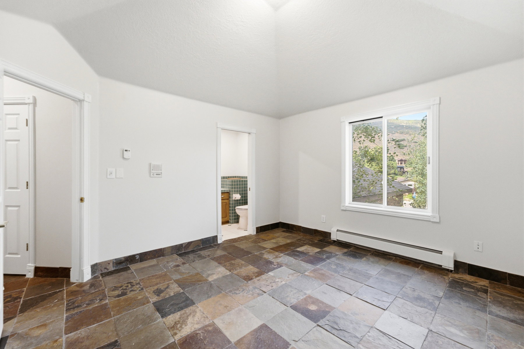 Neutral-toned room featuring multi-color slate flooring and a crisp white ceiling
