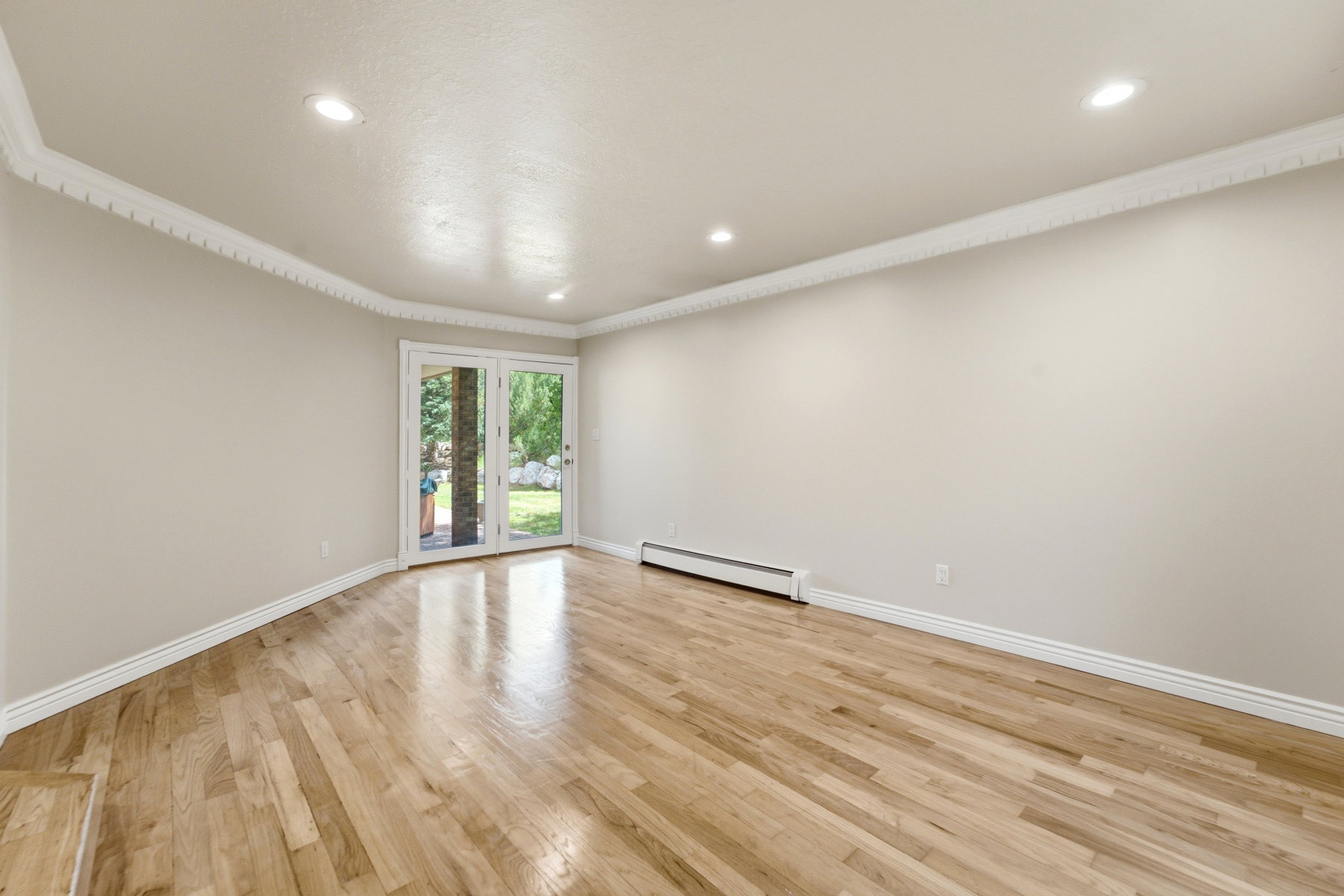 Room featuring hardwood flooring, light-toned walls, and recessed lighting