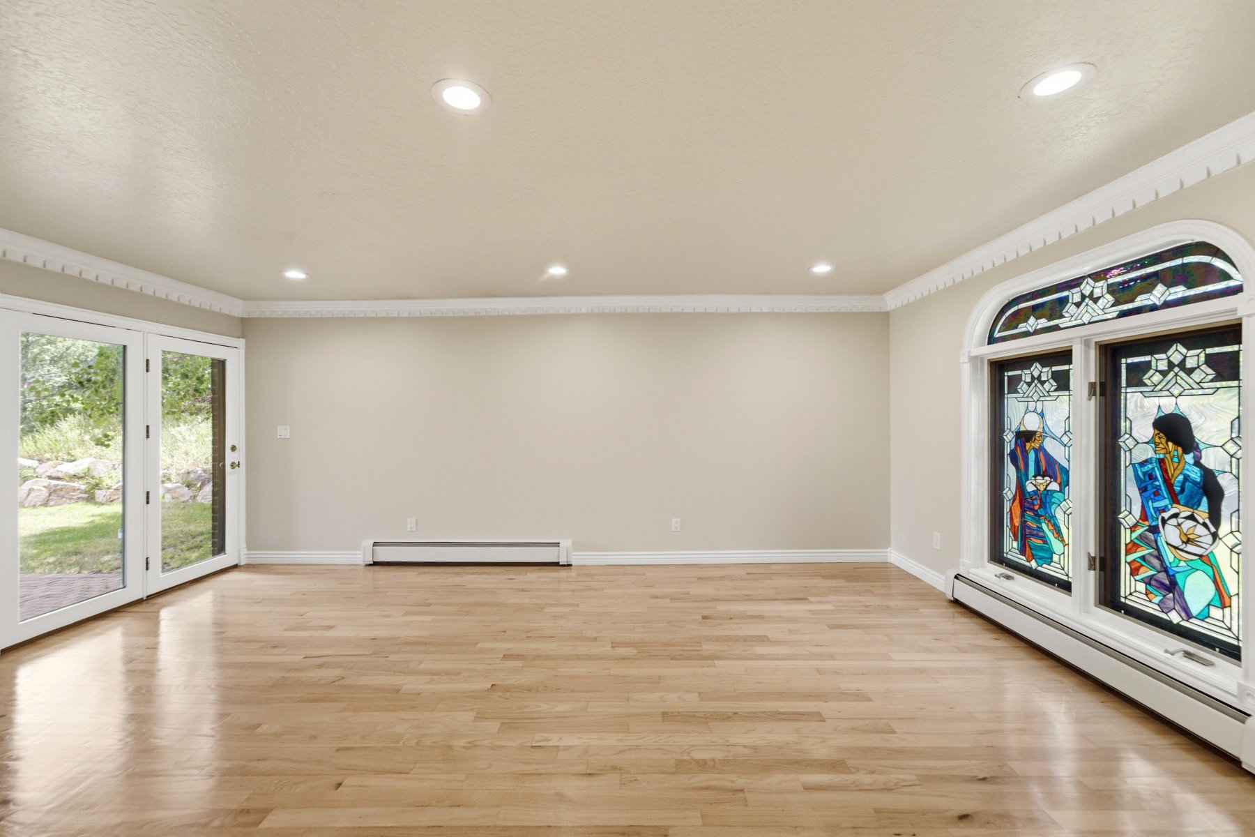 Spacious room featuring light wood-finish flooring, recessed lighting, and ornate crown molding