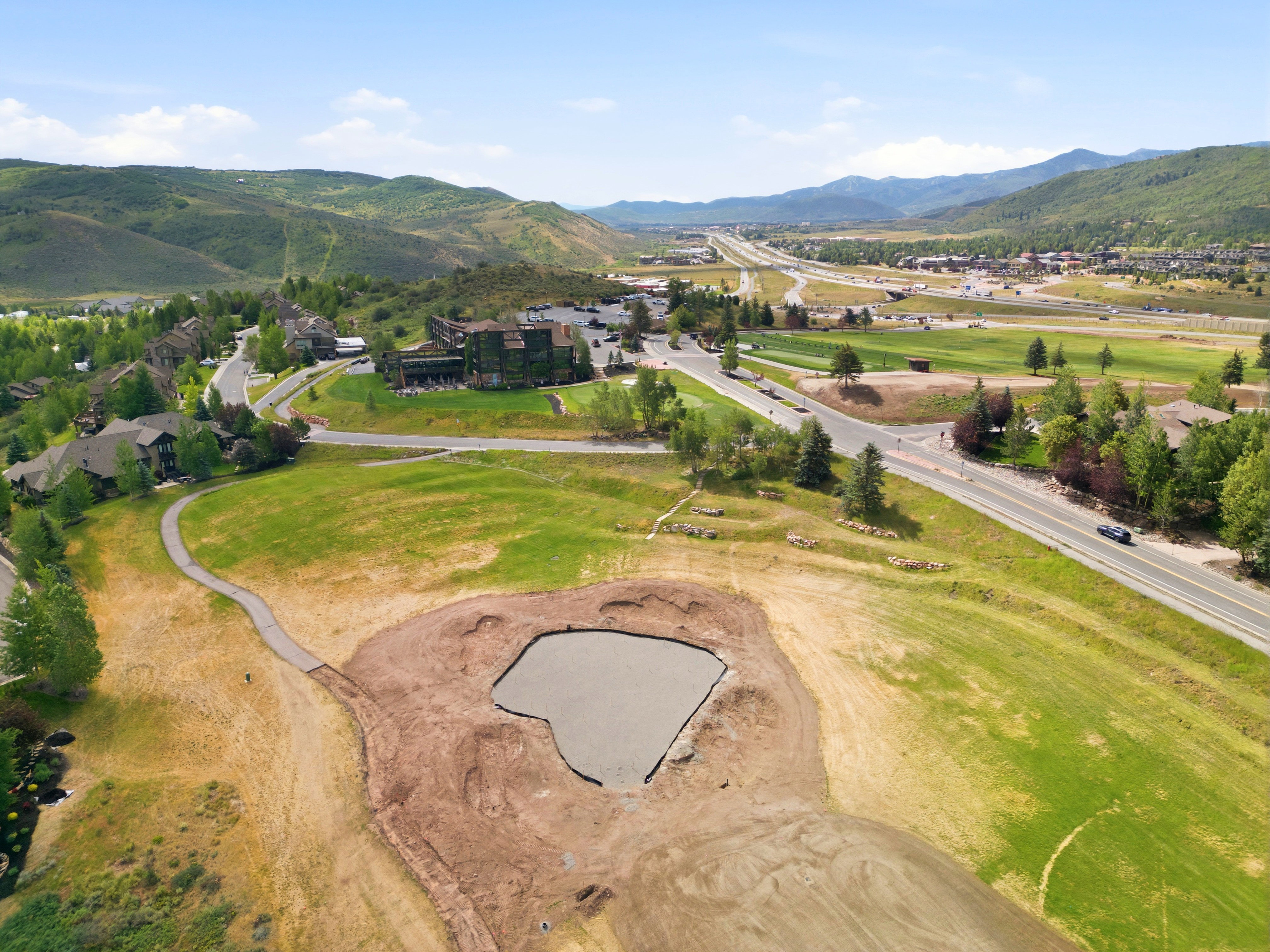 Expansive lot featuring a prepared pad for construction and a surrounding grassy area