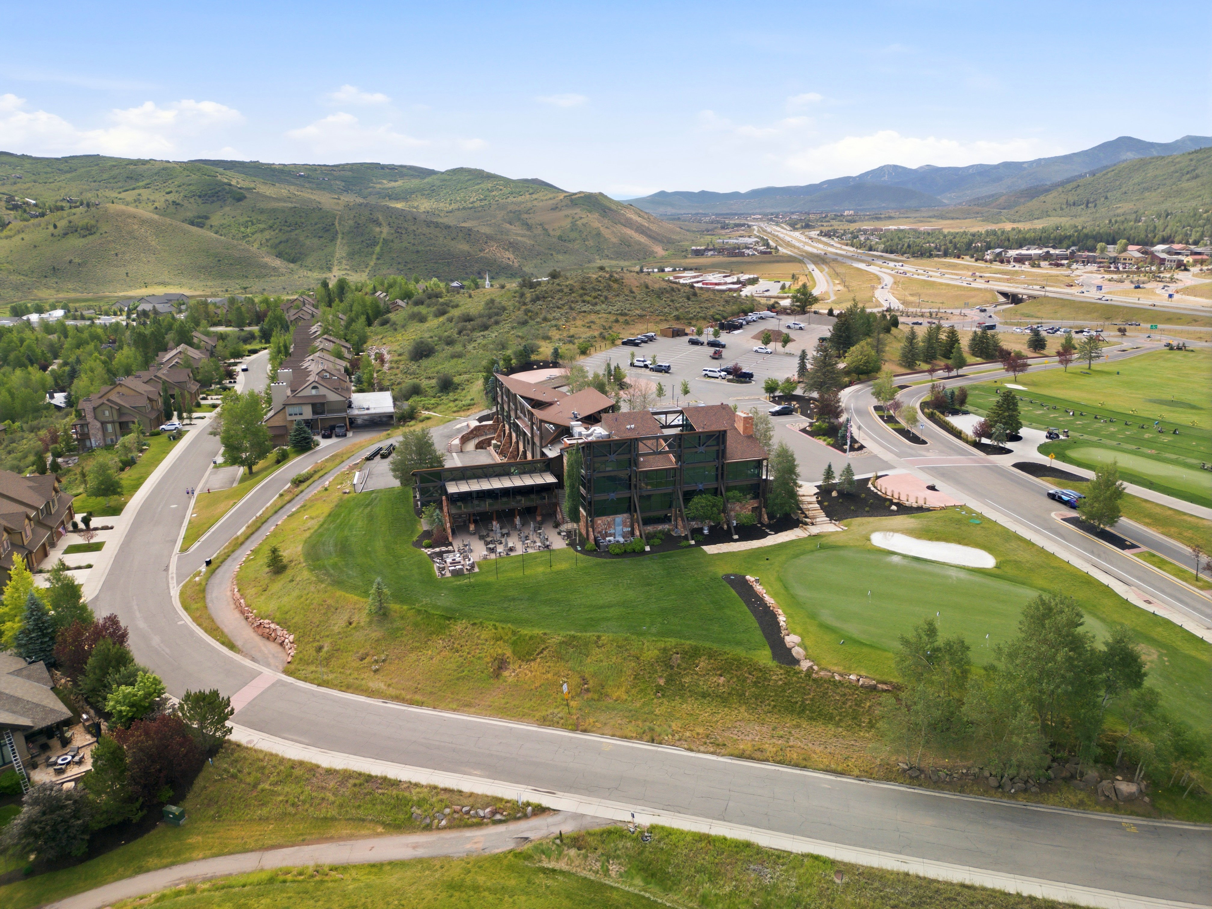 Mountainous terrain with a multi-story building featuring a prominent outdoor patio area