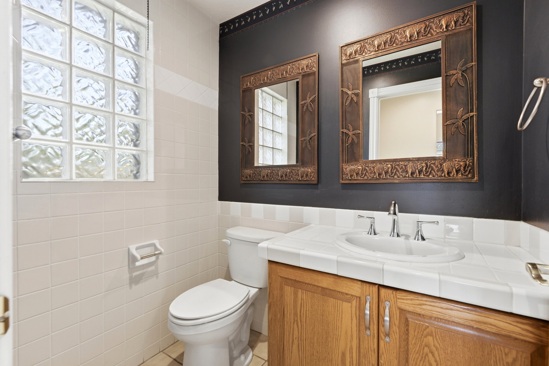 Bathroom featuring a wood-finish vanity with an integrated sink and a tile countertop