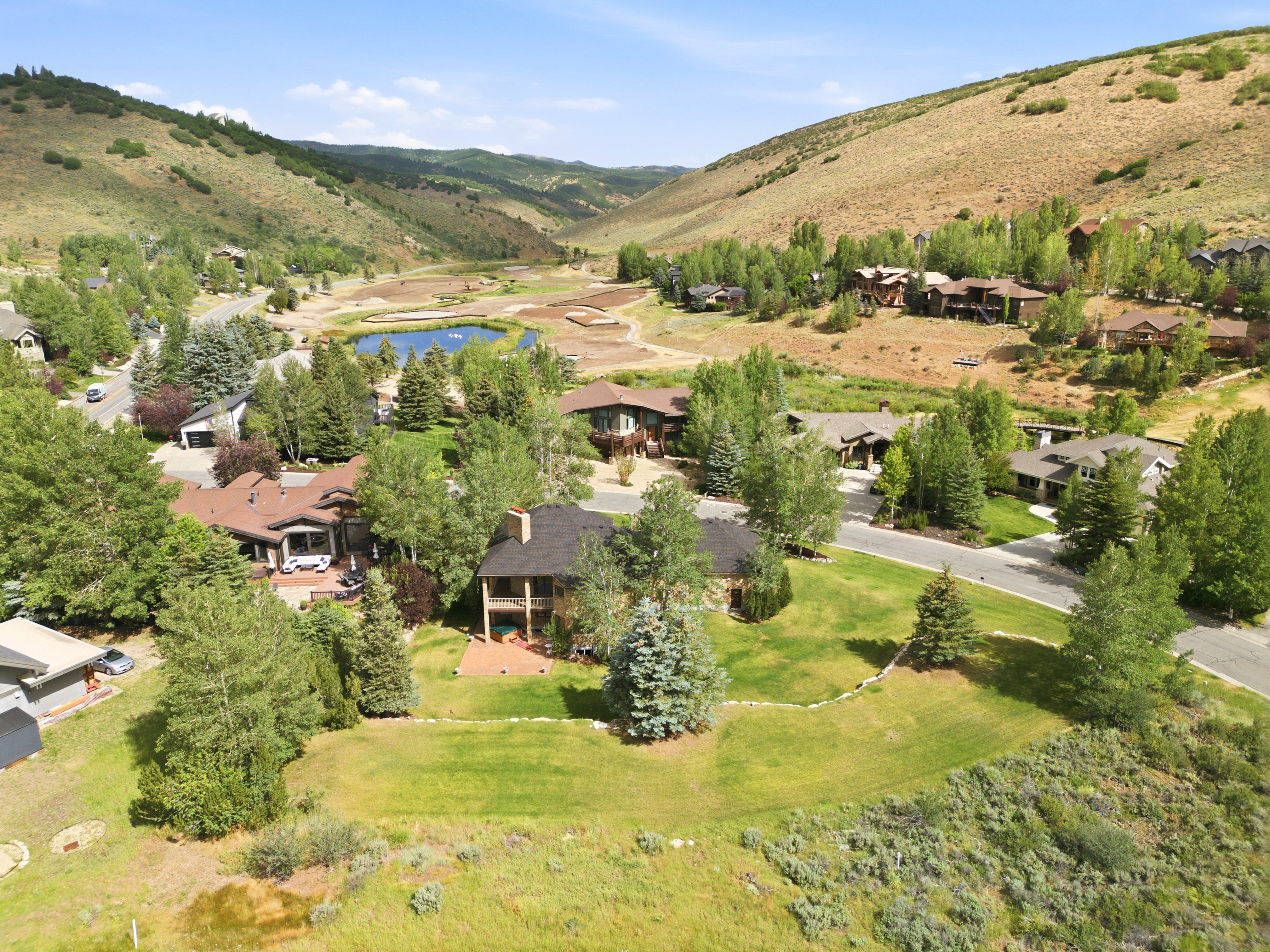 Lush green landscaping with mature trees surrounding the property