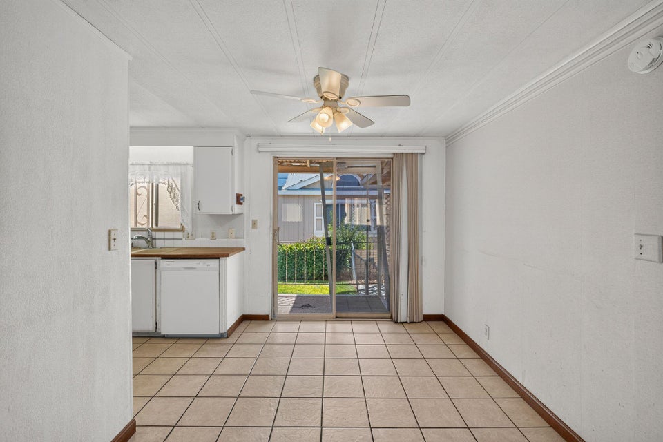 Dining area featuring tile flooring, a ceiling fan, crown molding, and sliding glass doors opening to the exterior