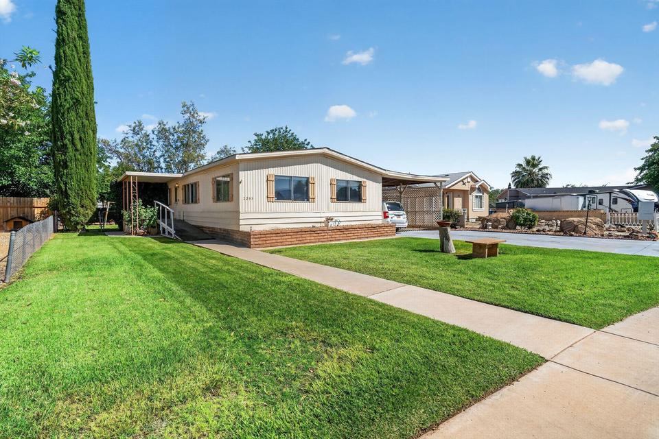 Single-story residence featuring light-colored siding and a brick-look foundation