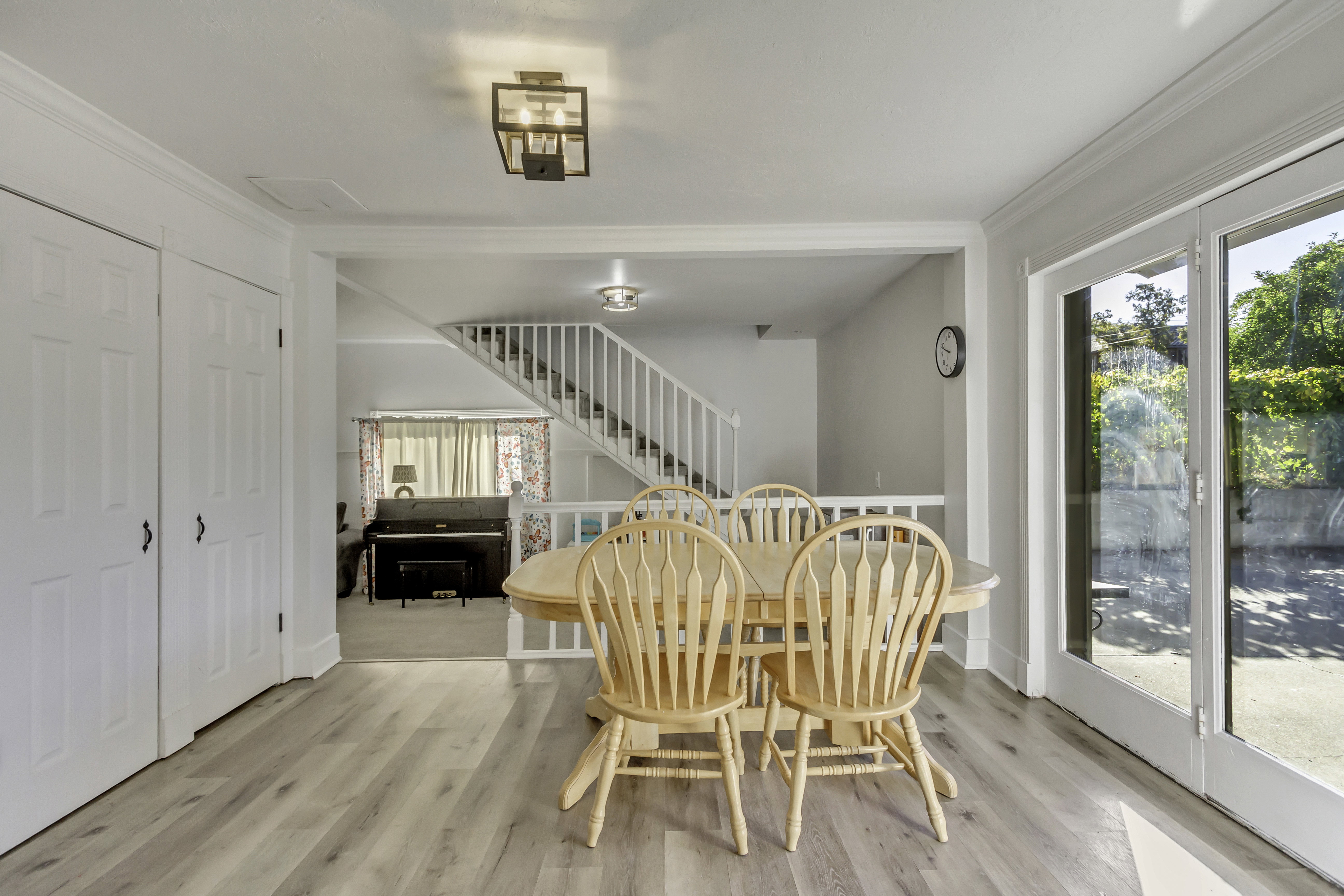 Light wood-finish flooring extending into a dining area featuring French doors