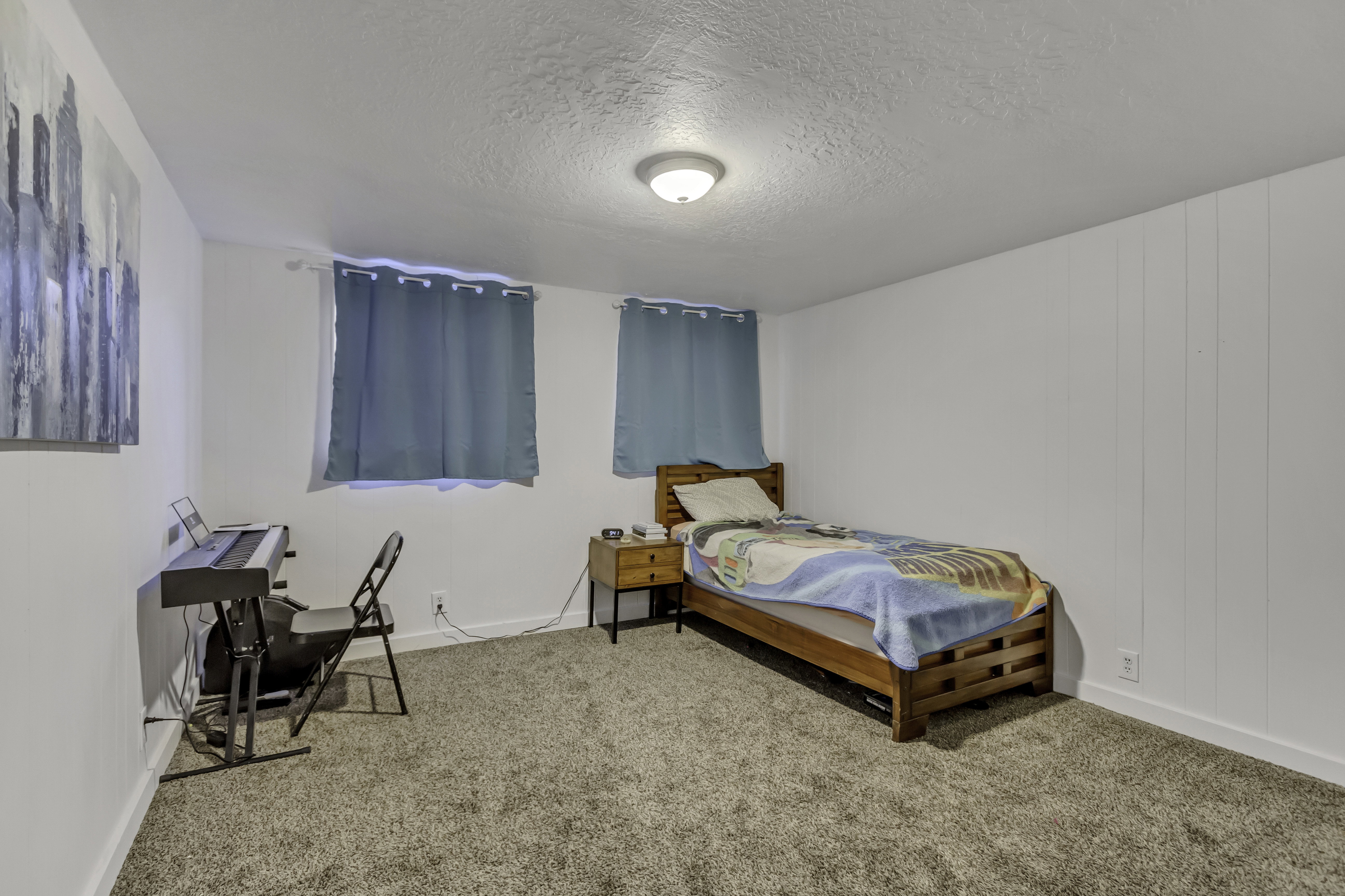Carpeted room with white walls, two windows, and a flush-mount ceiling light