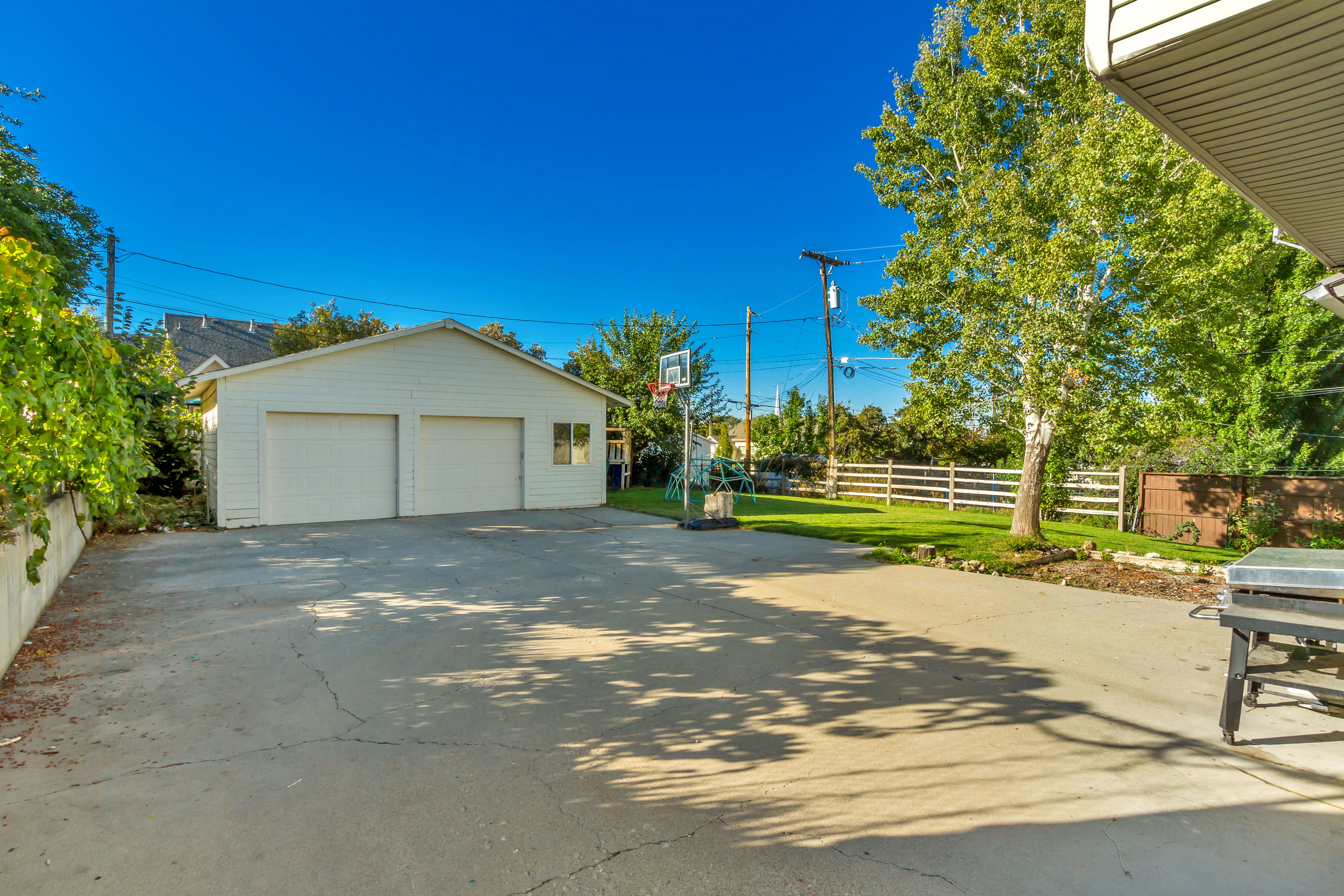 Detached two-car garage with white paneled doors and a concrete driveway