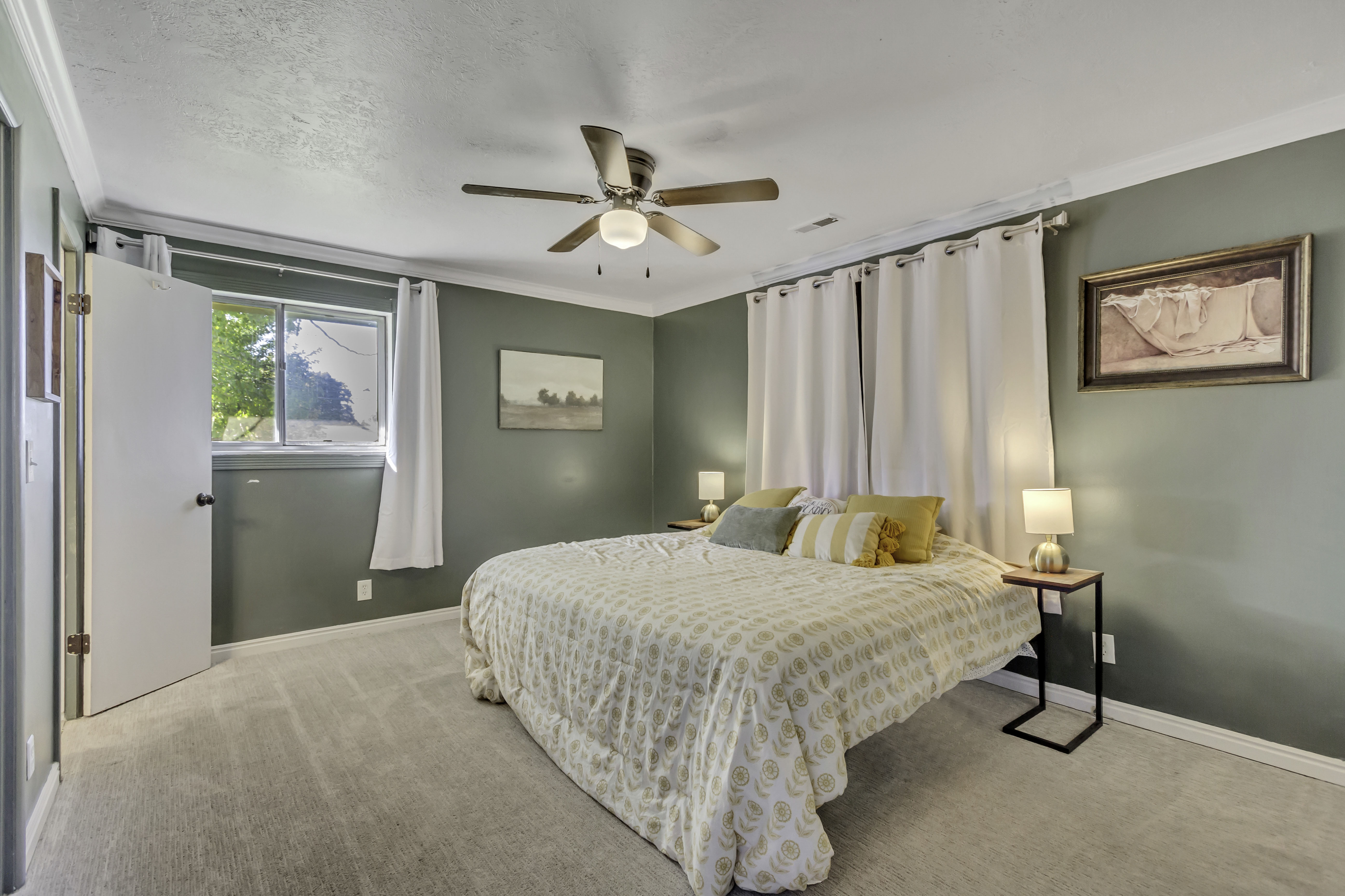 Carpeted bedroom with green walls and a ceiling fan