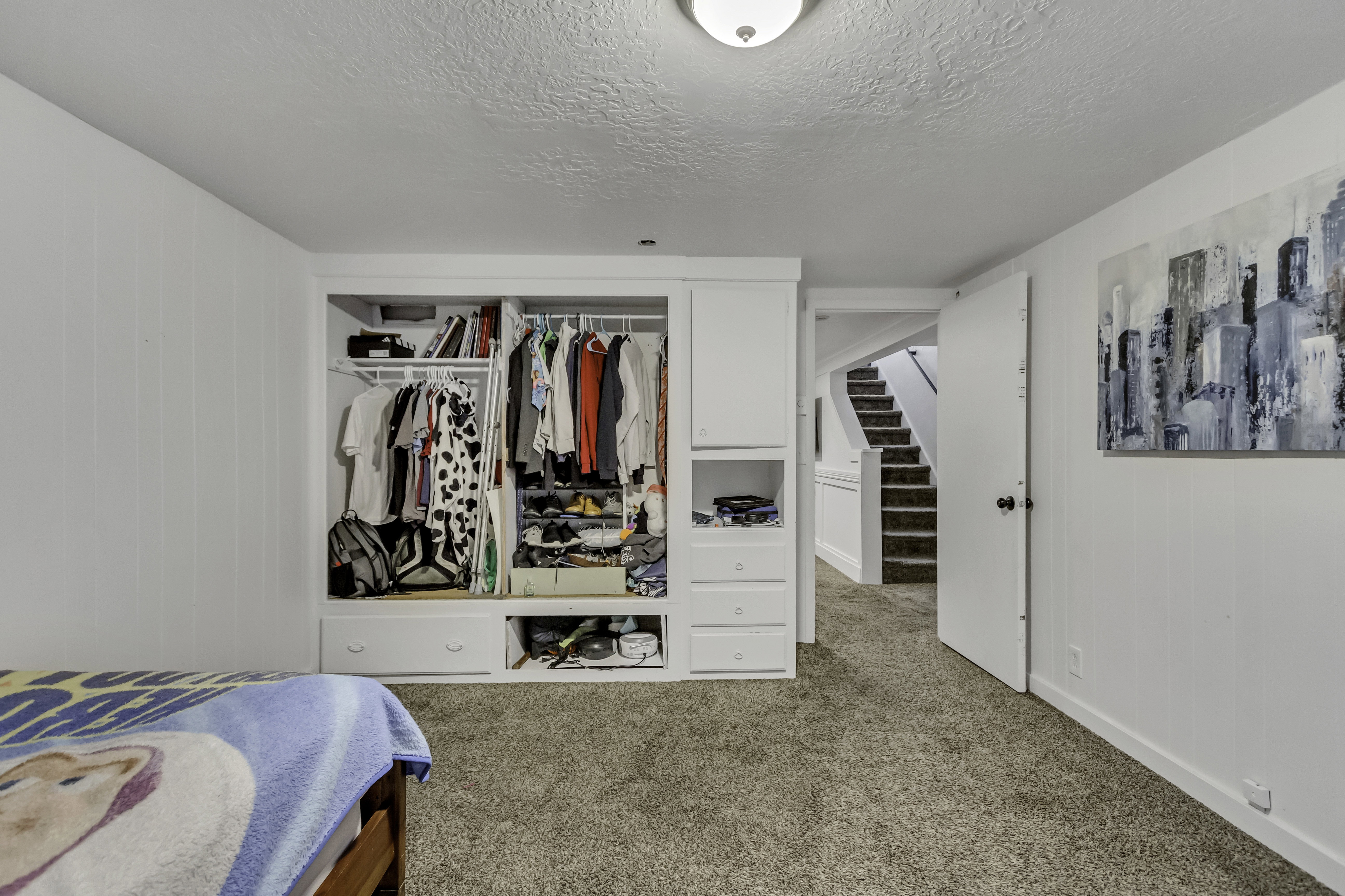 Built-in closet system featuring multiple hanging rods, shelving, and lower drawers