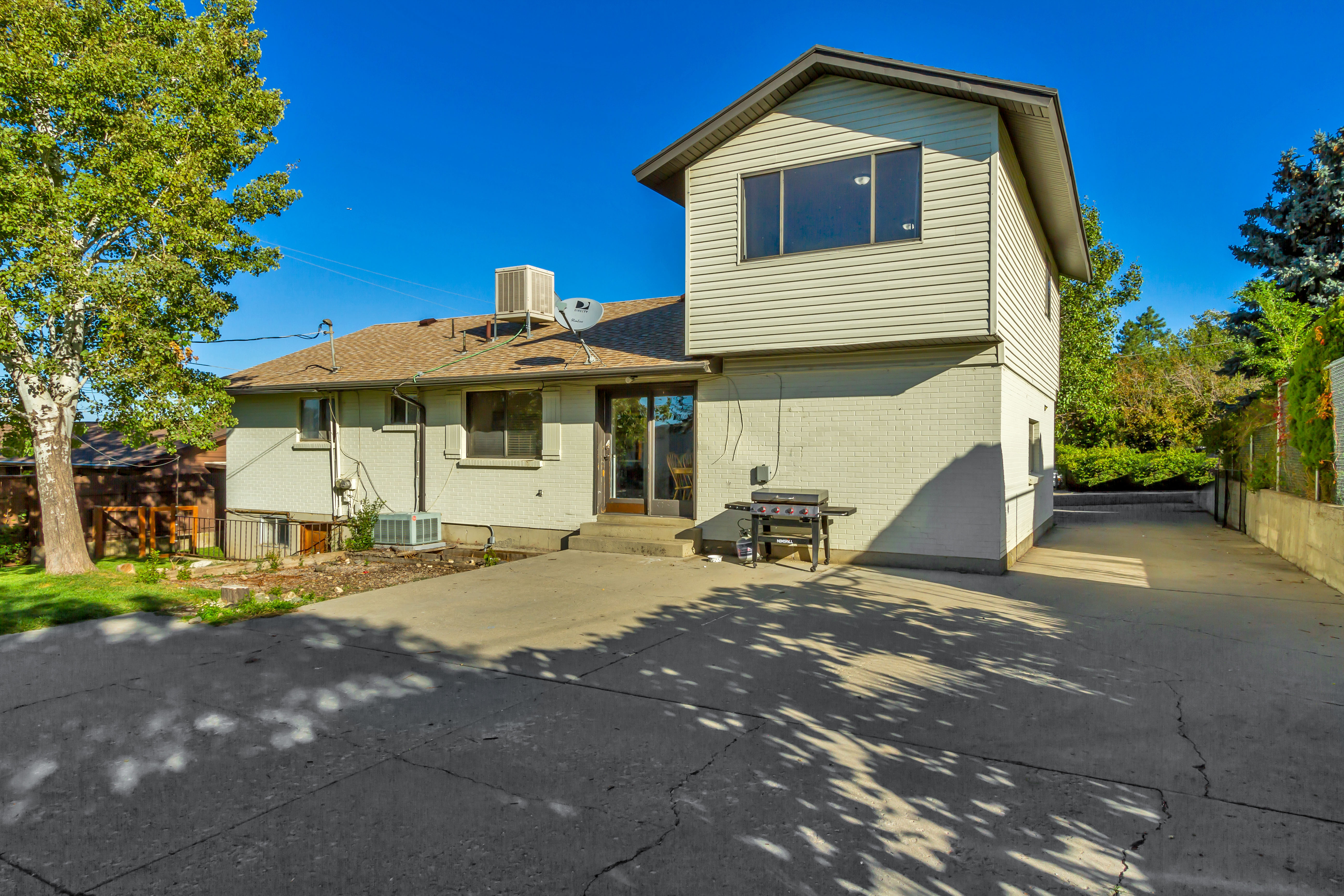Rear exterior featuring a two-story addition with horizontal siding and multiple windows