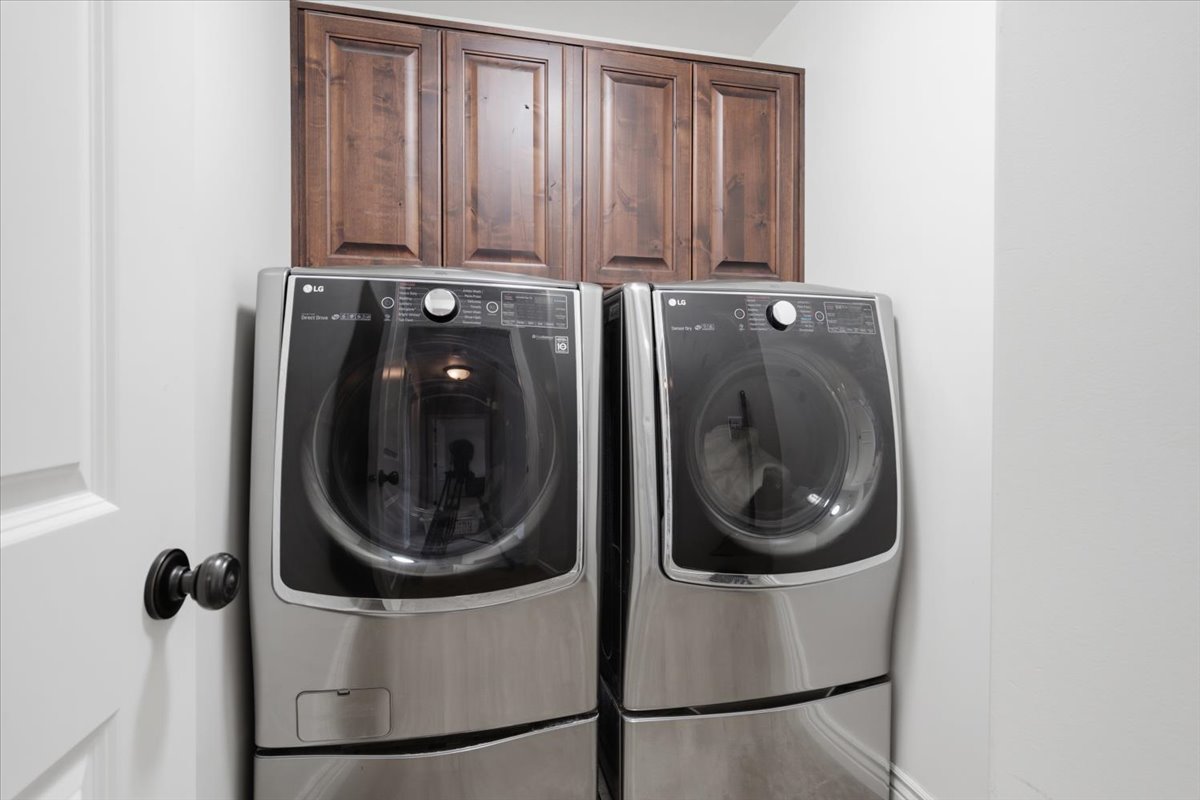 Laundry area featuring dark wood-finish cabinetry
