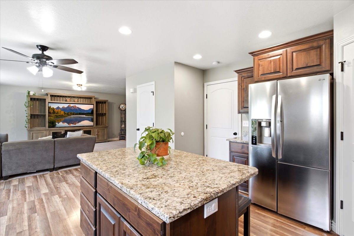 Kitchen island with granite countertop and wood-finish cabinetry