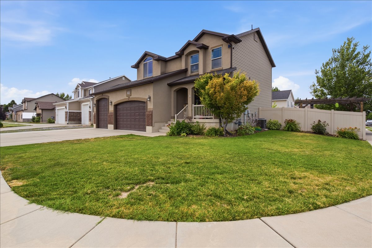 Stucco and siding exterior with a prominent two-car garage featuring arched doors