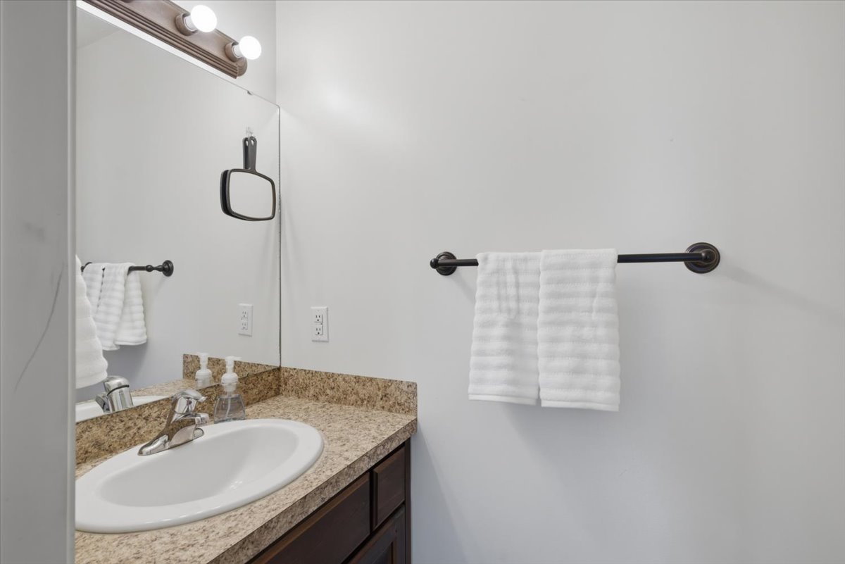 Bathroom vanity with laminate countertop, integrated sink, and chrome faucet