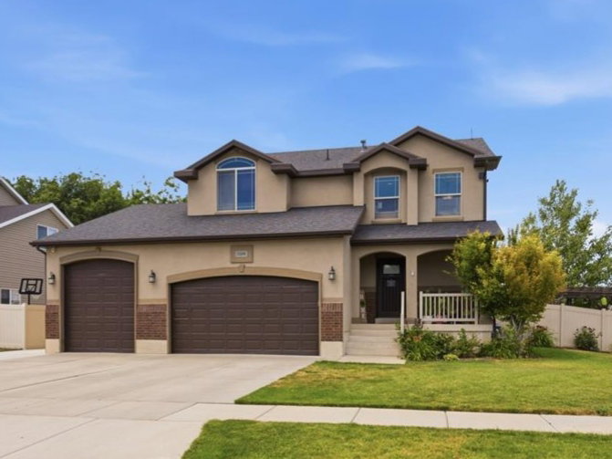 Contemporary two-story residence with a stucco exterior and brick accents