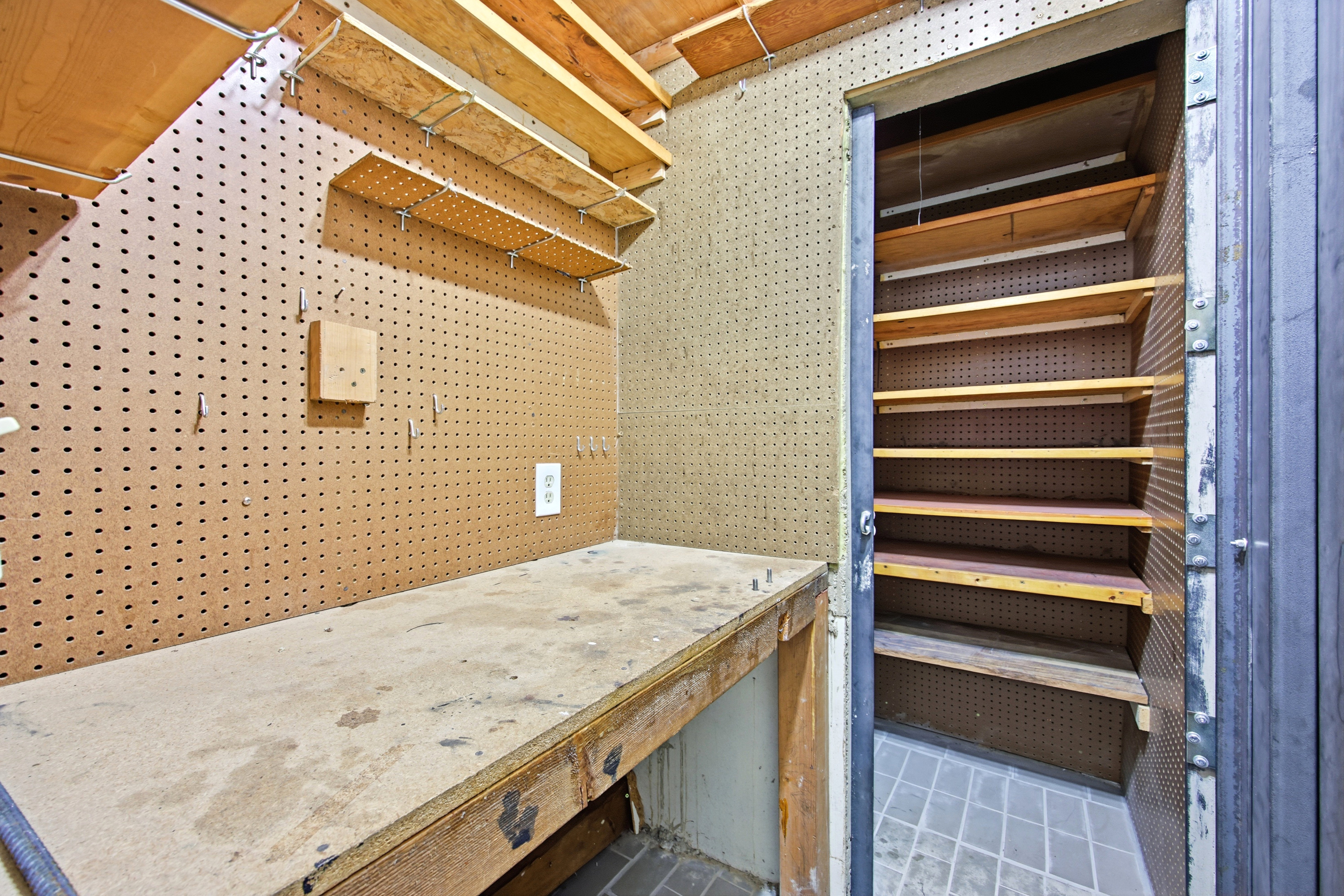 Dedicated workspace featuring a built-in workbench, pegboard wall, and integrated shelving