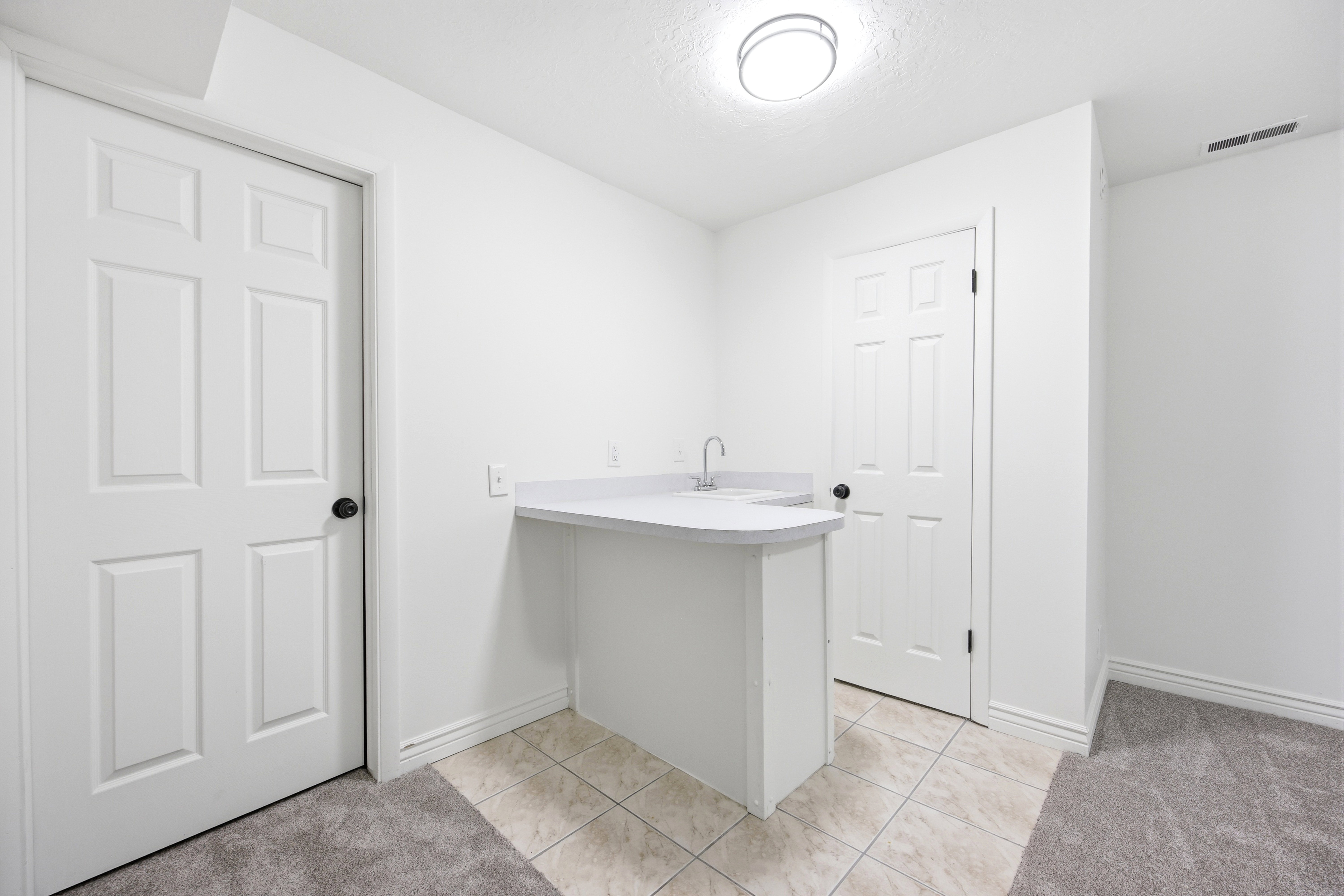 Wet bar featuring a built-in sink, countertop, and tiled flooring