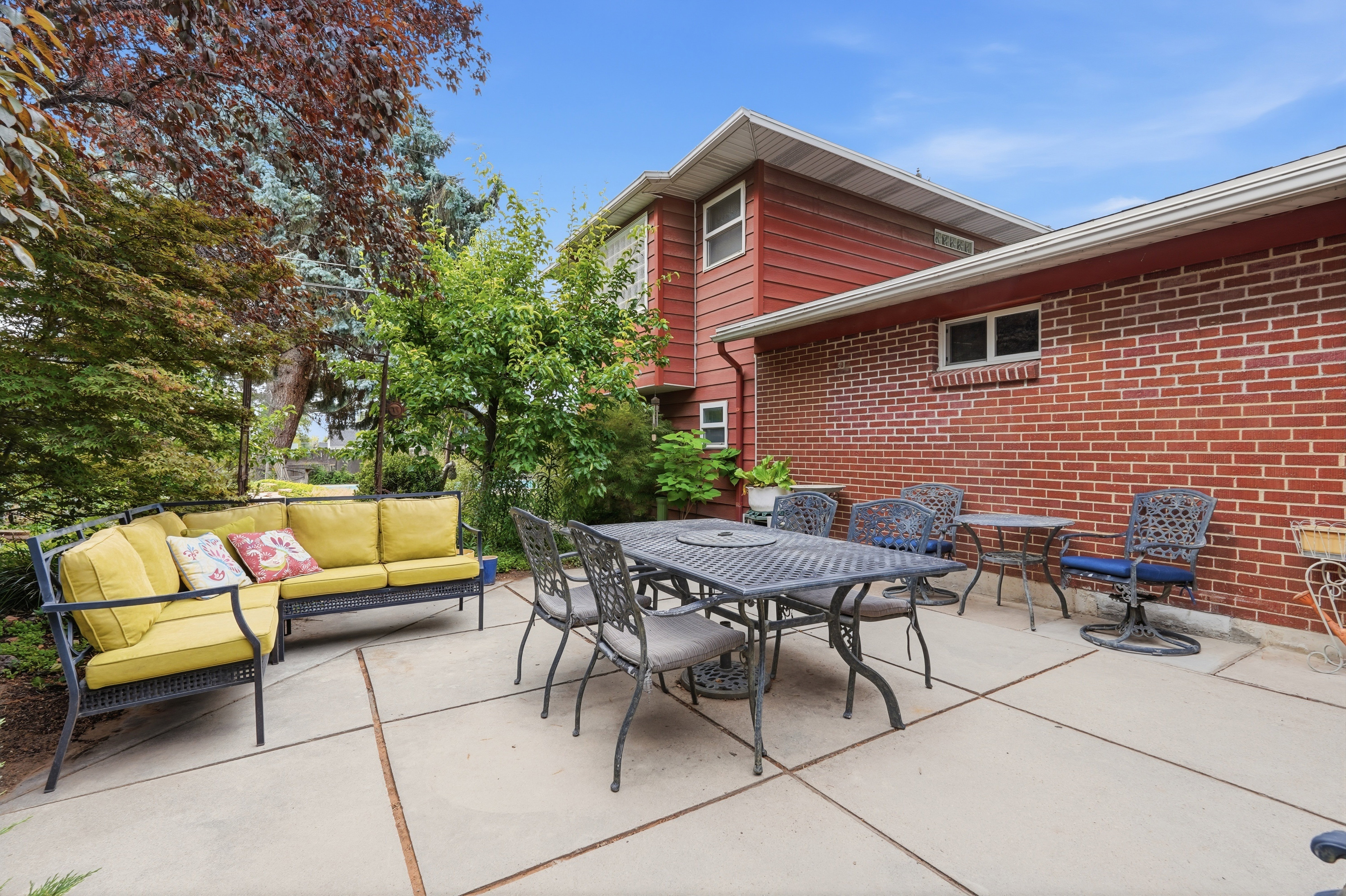 Expansive concrete patio with brick and siding exterior