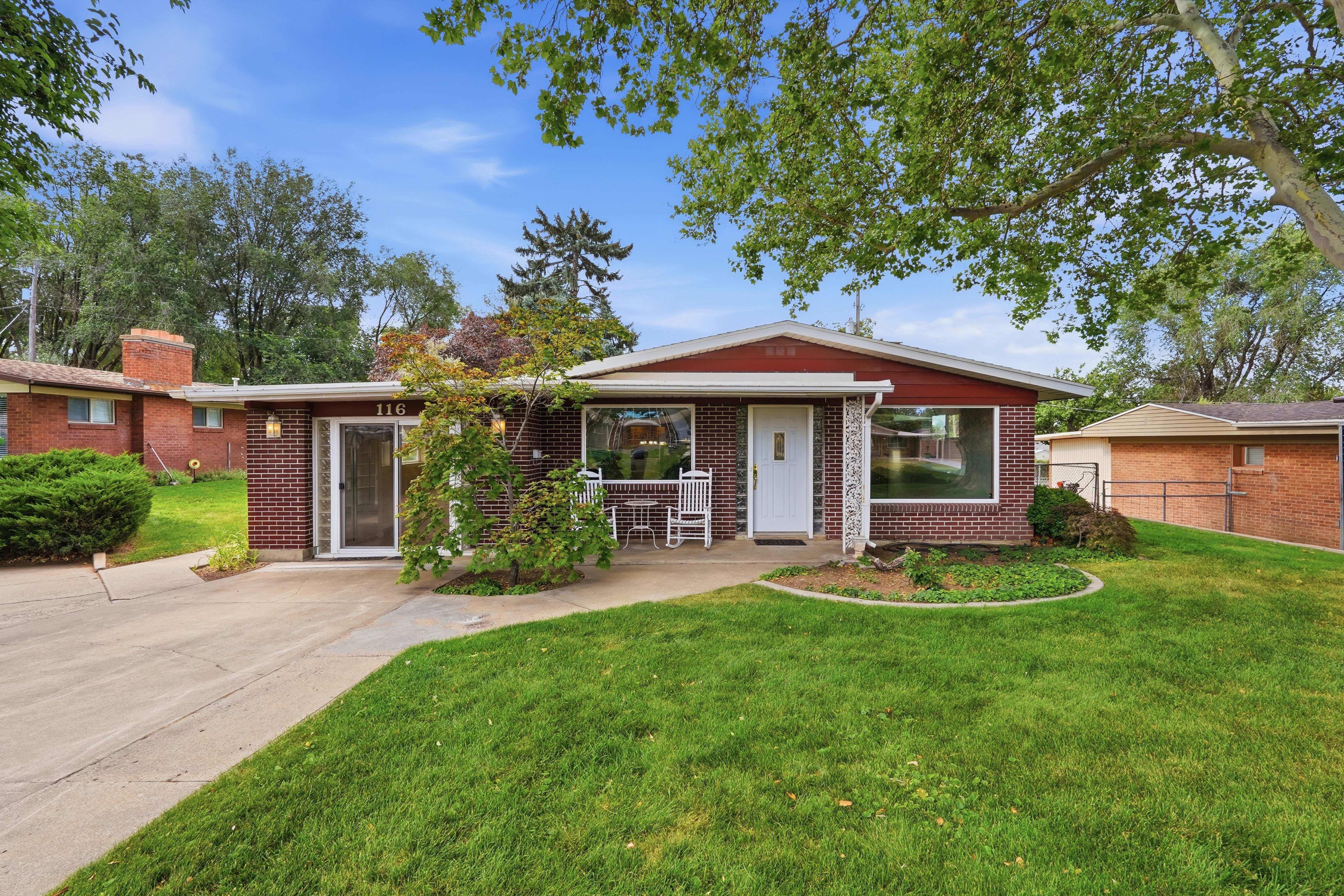 Brick facade home with a red trim roofline and a well-maintained front lawn
