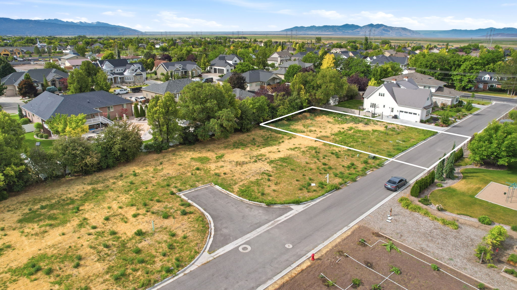 Spacious undeveloped lot with clear property boundaries, surrounded by established residential properties