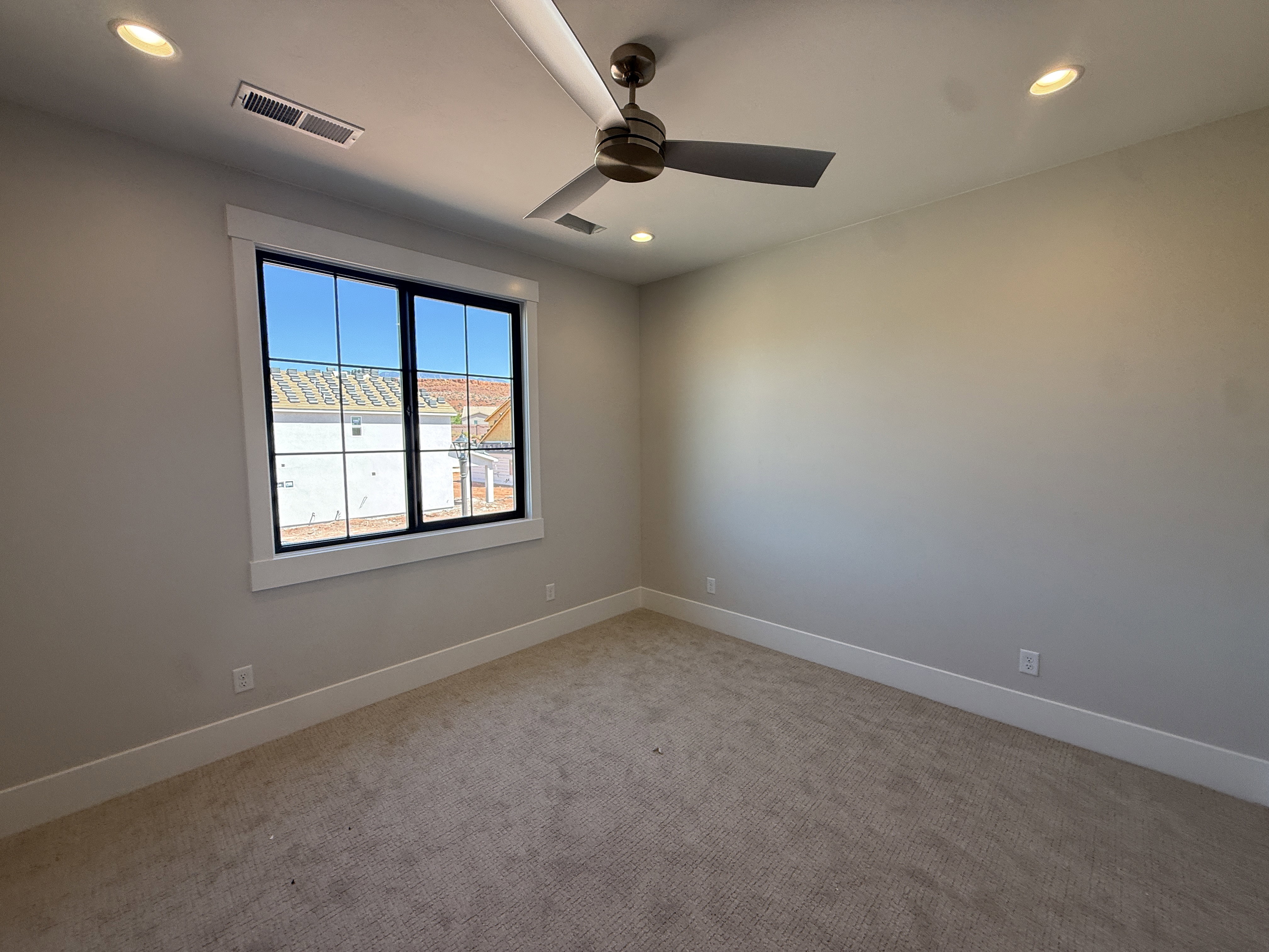 Room featuring a large window with black framing, ceiling fan, and recessed lighting