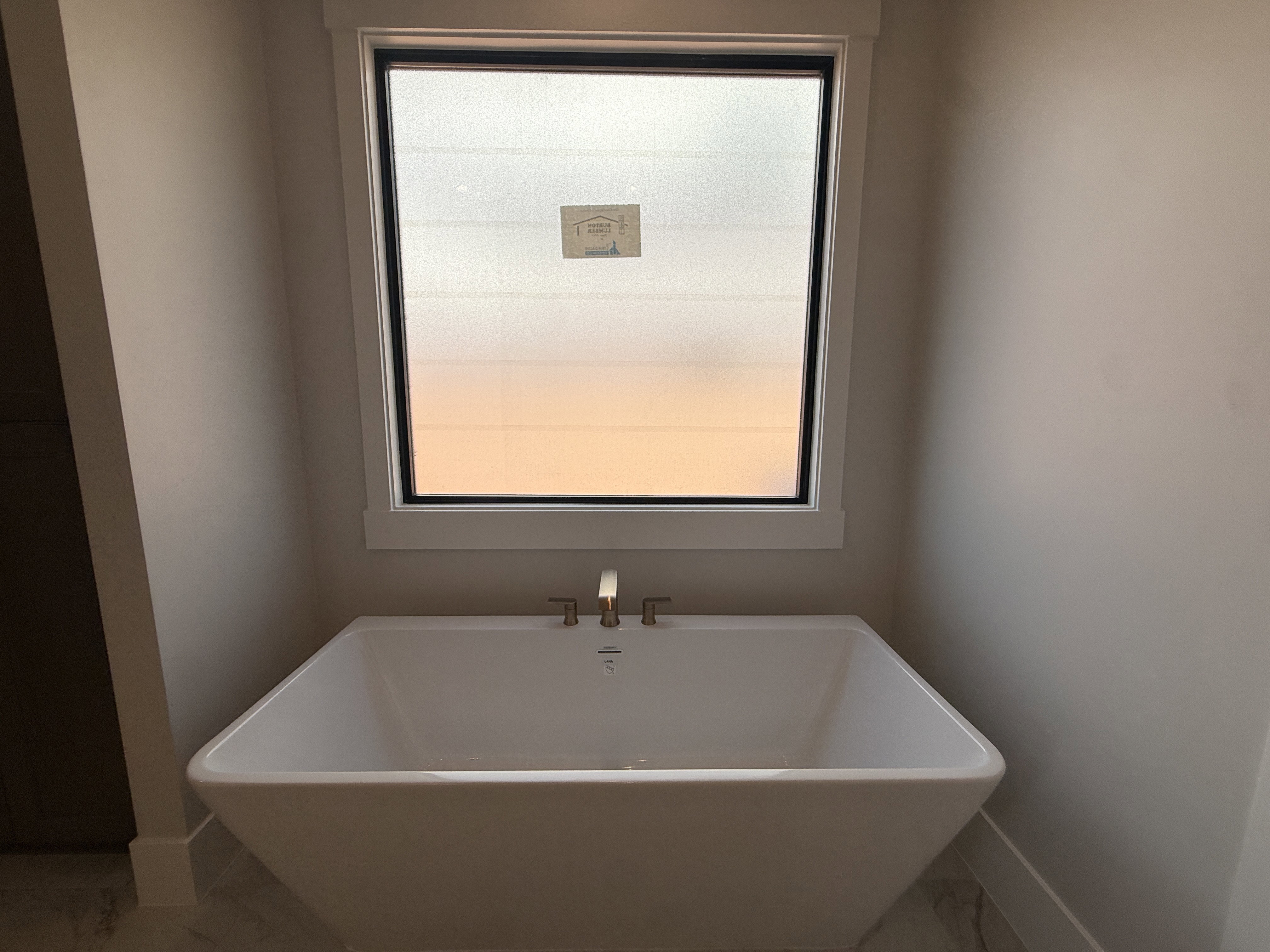 Freestanding soaking tub with brushed brass fixtures