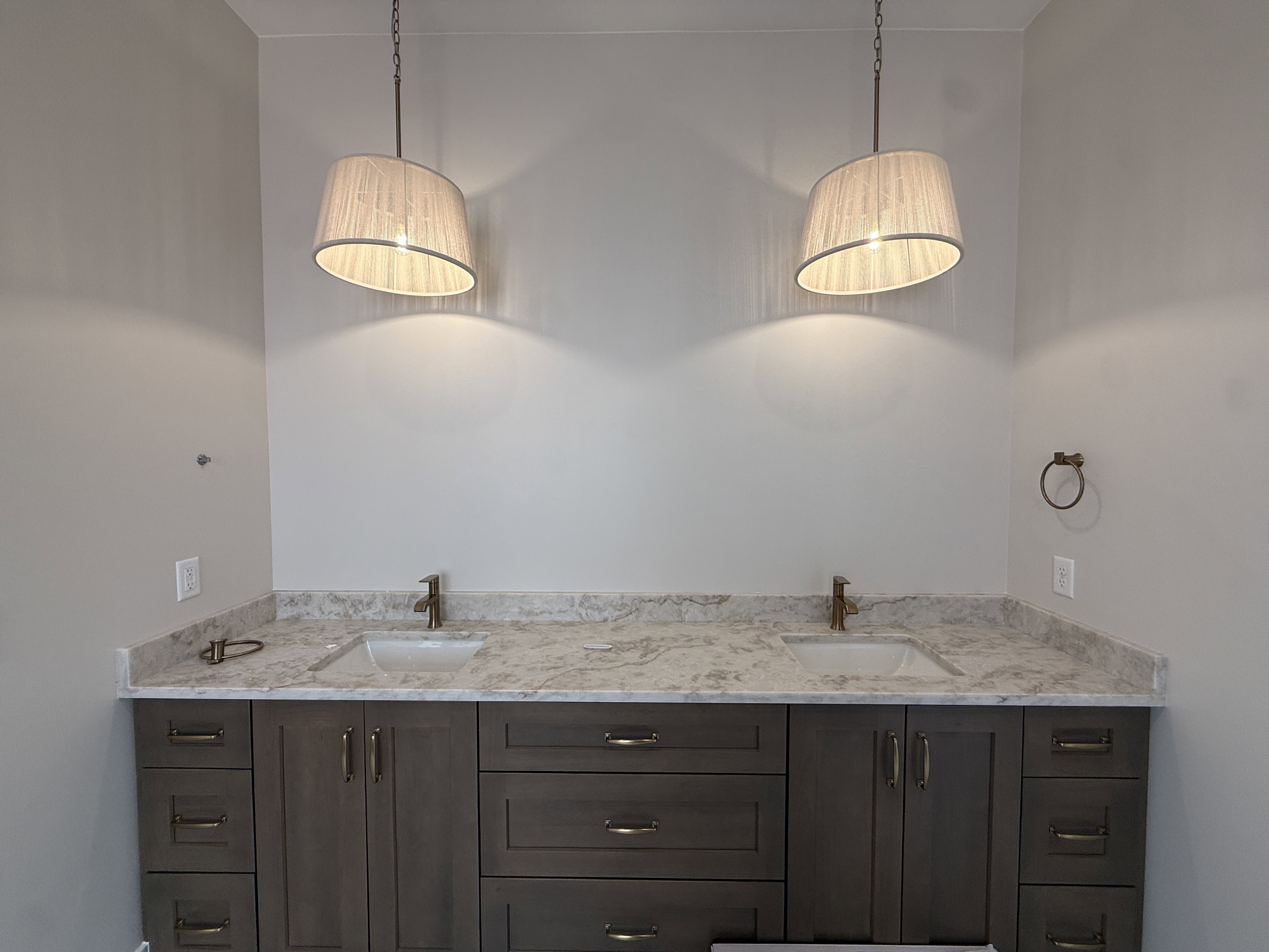 Double vanity featuring a light-toned countertop, dual undermount sinks, and bronze-finish fixtures