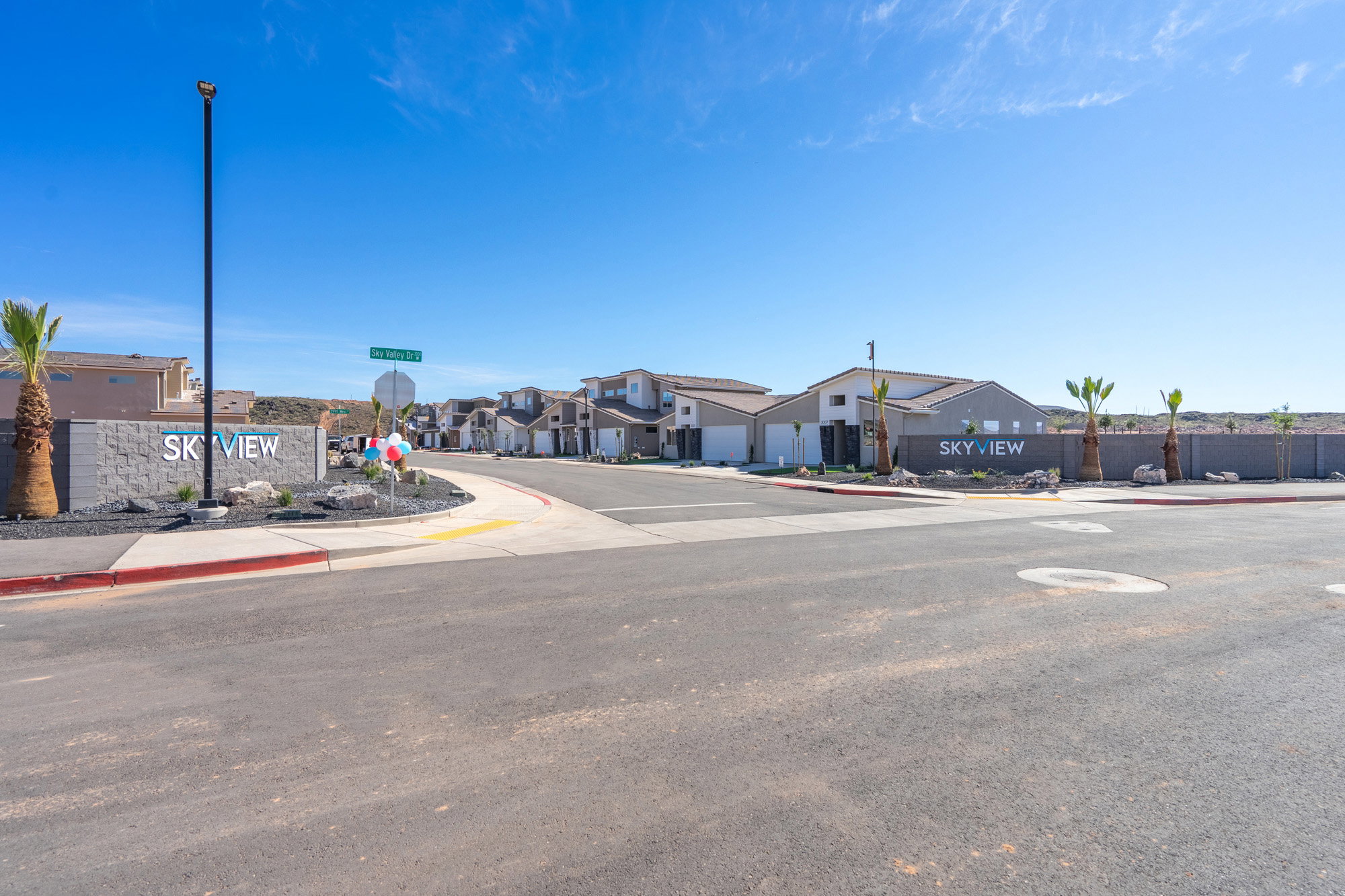 View of asphalt street with sidewalks, curbs, traffic signs, a residential view, and street lighting