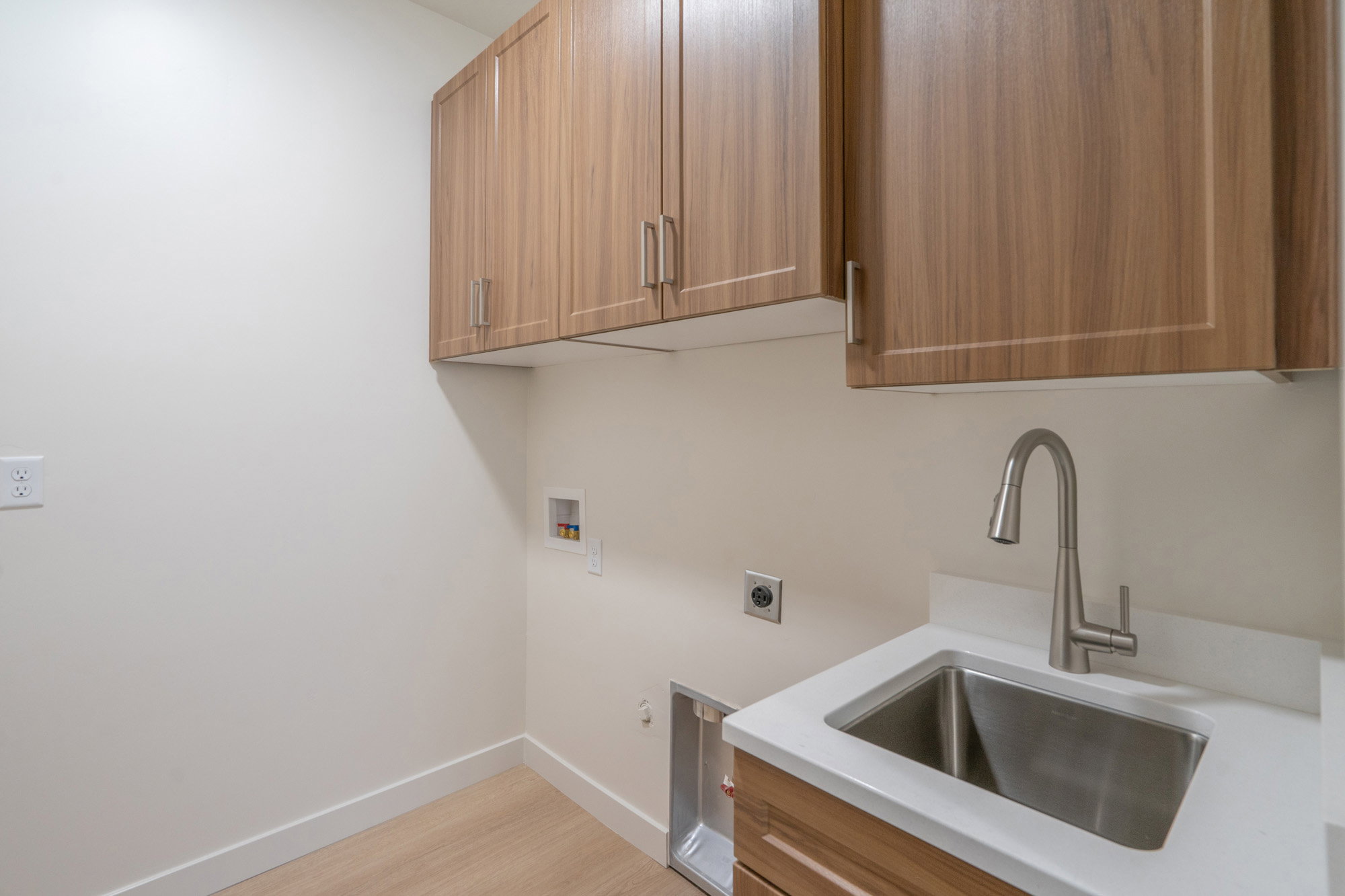 Laundry area featuring hookup for an electric dryer, washer hookup, light wood-style floors, gas dryer hookup, and cabinet space