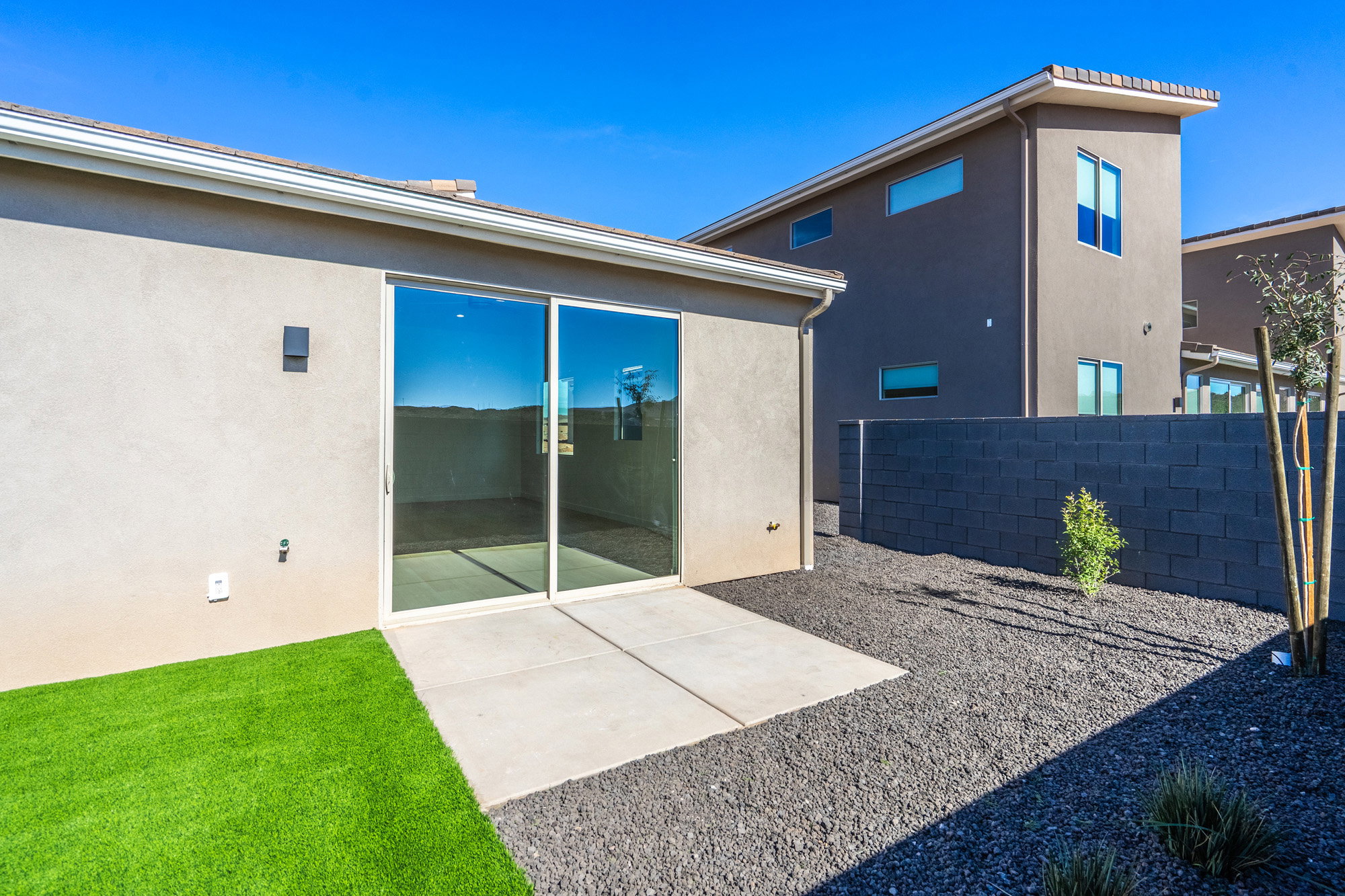Back of house with stucco siding and a patio