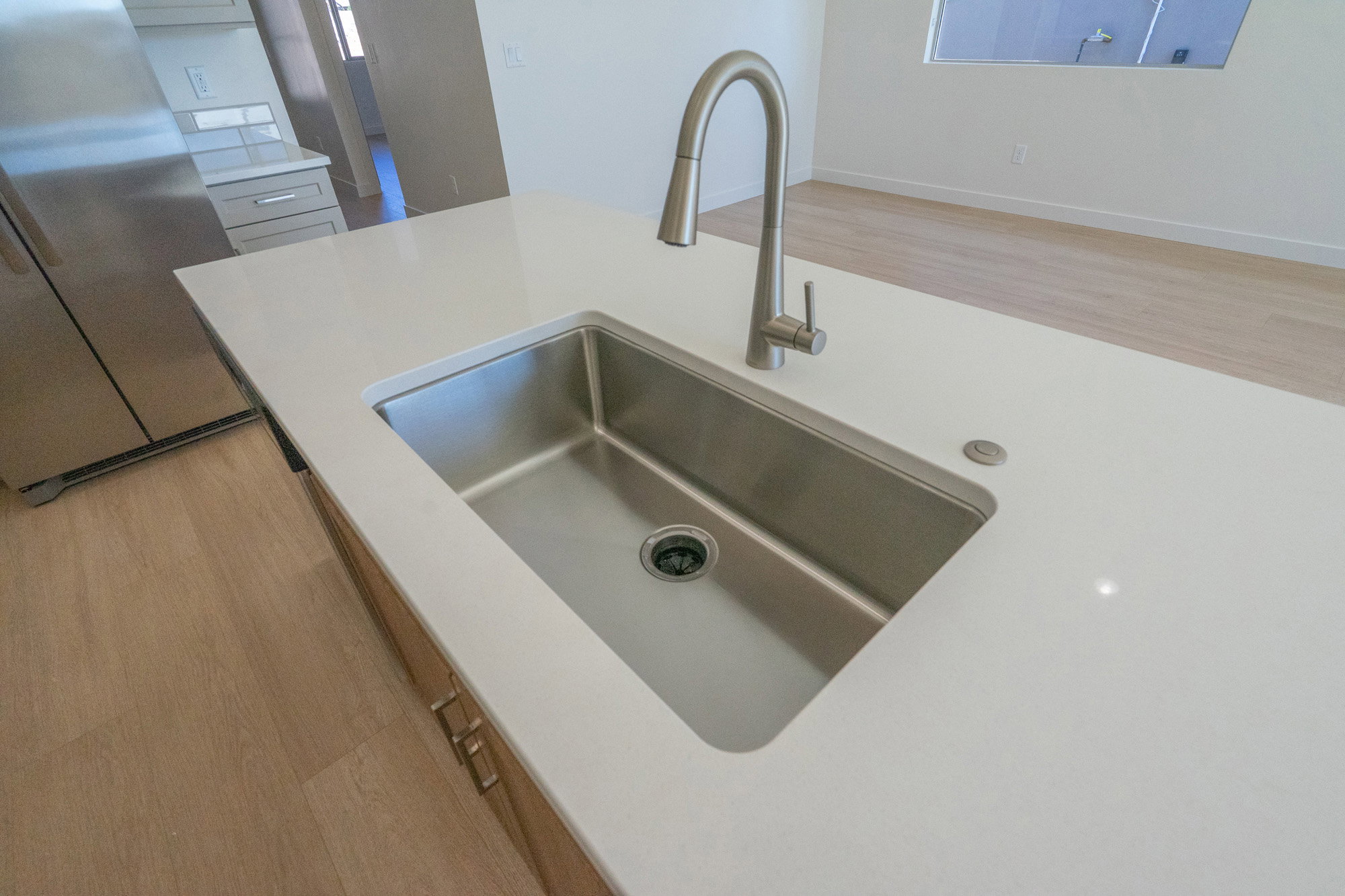 Kitchen view of light wood-type flooring and freestanding refrigerator