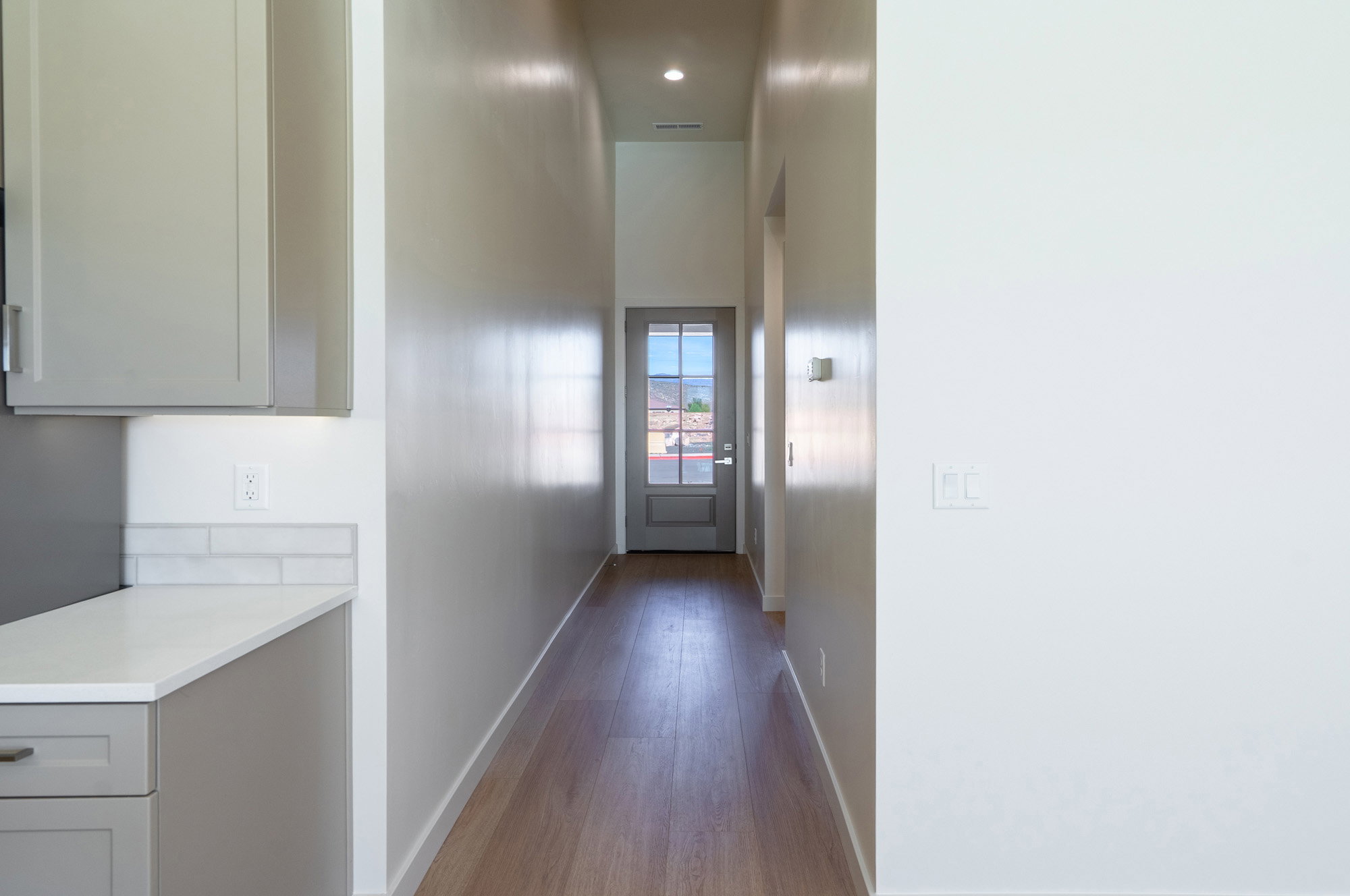 Corridor with dark wood-style flooring and recessed lighting
