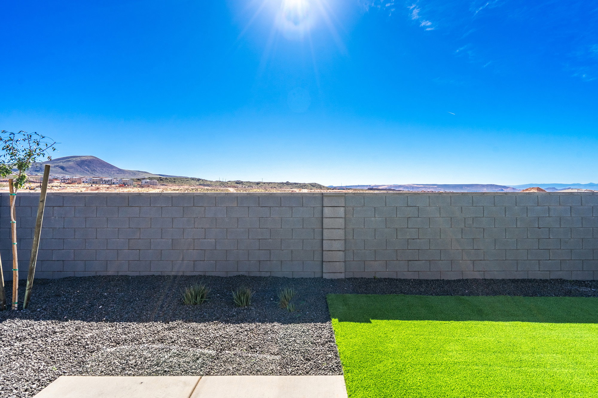Exterior view of a mountain backdrop and a fenced backyard