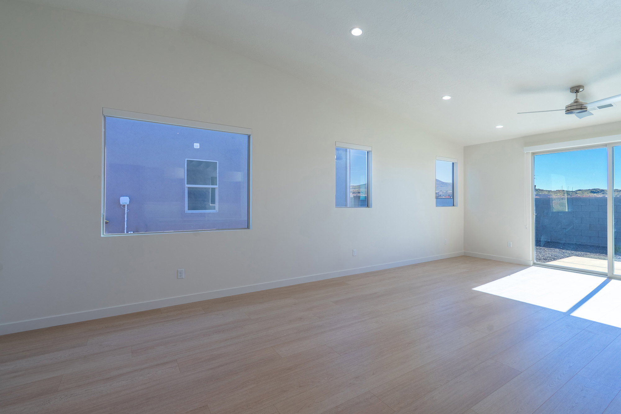 Spare room with lofted ceiling, ceiling fan, light wood finished floors, and recessed lighting