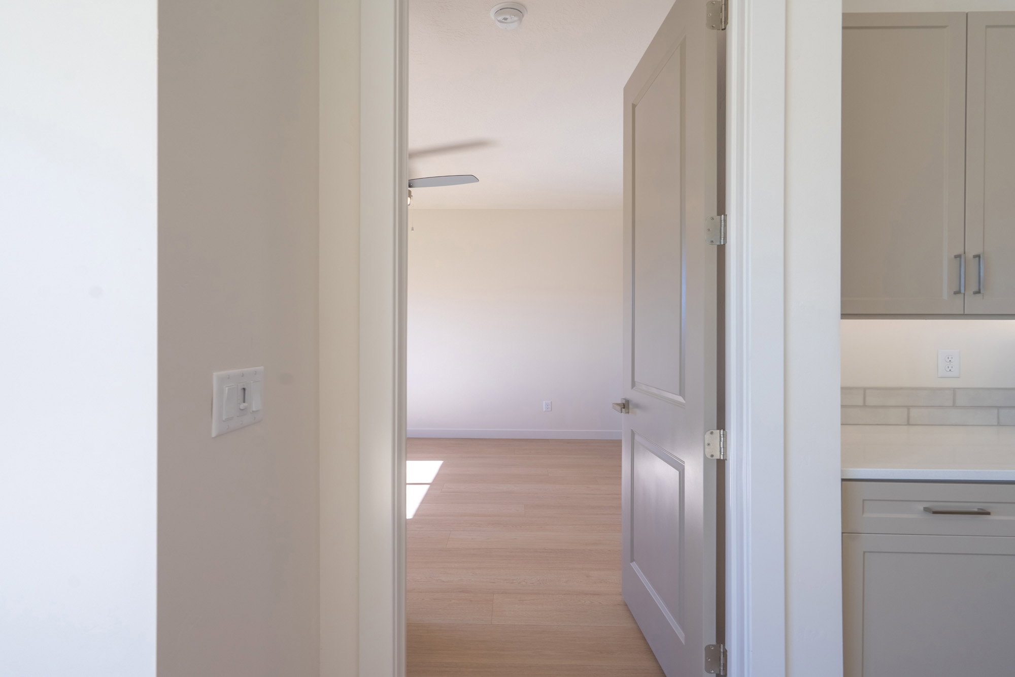 Hallway with light wood-type flooring and baseboards