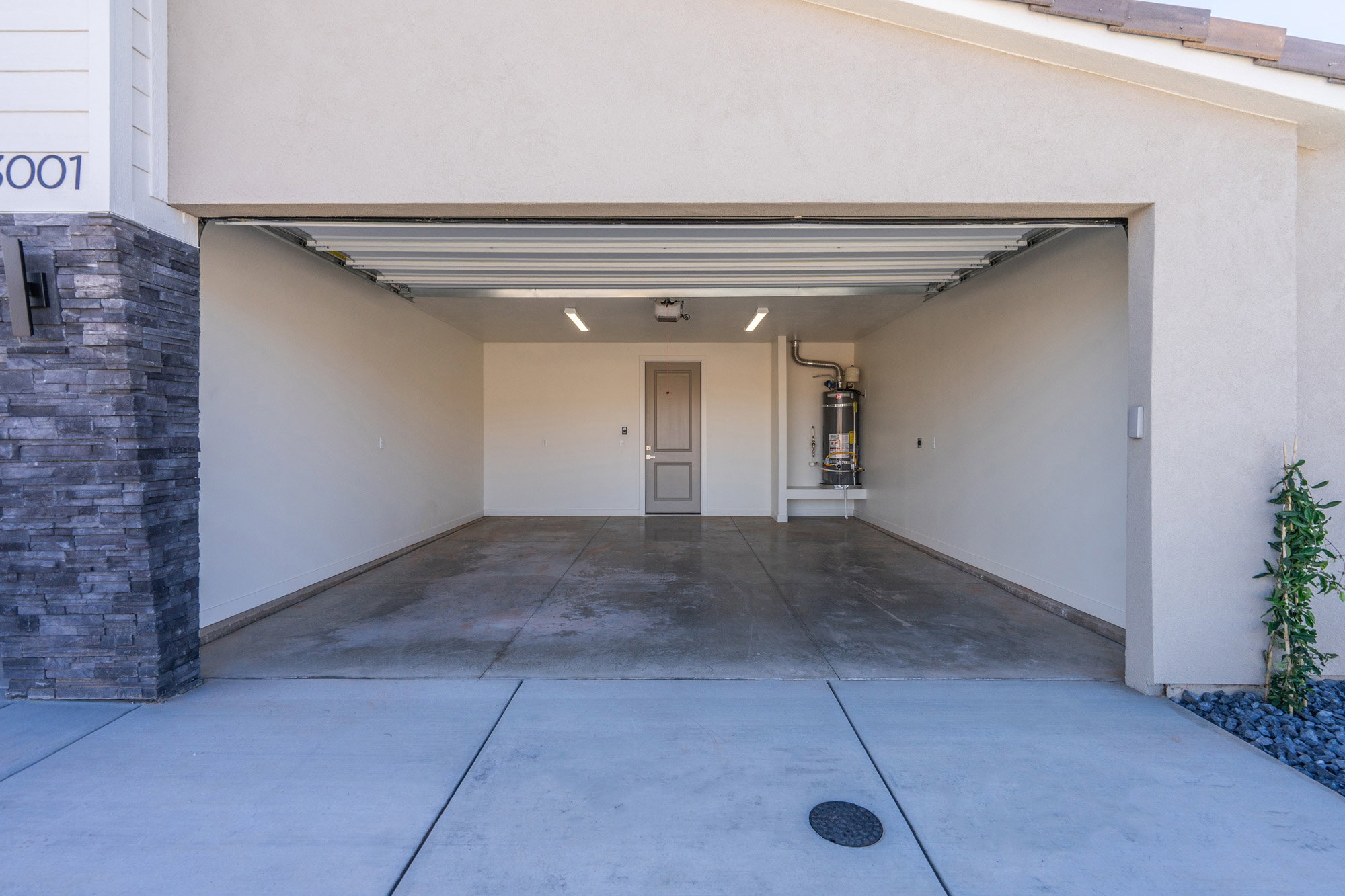 Garage featuring driveway and secured water heater
