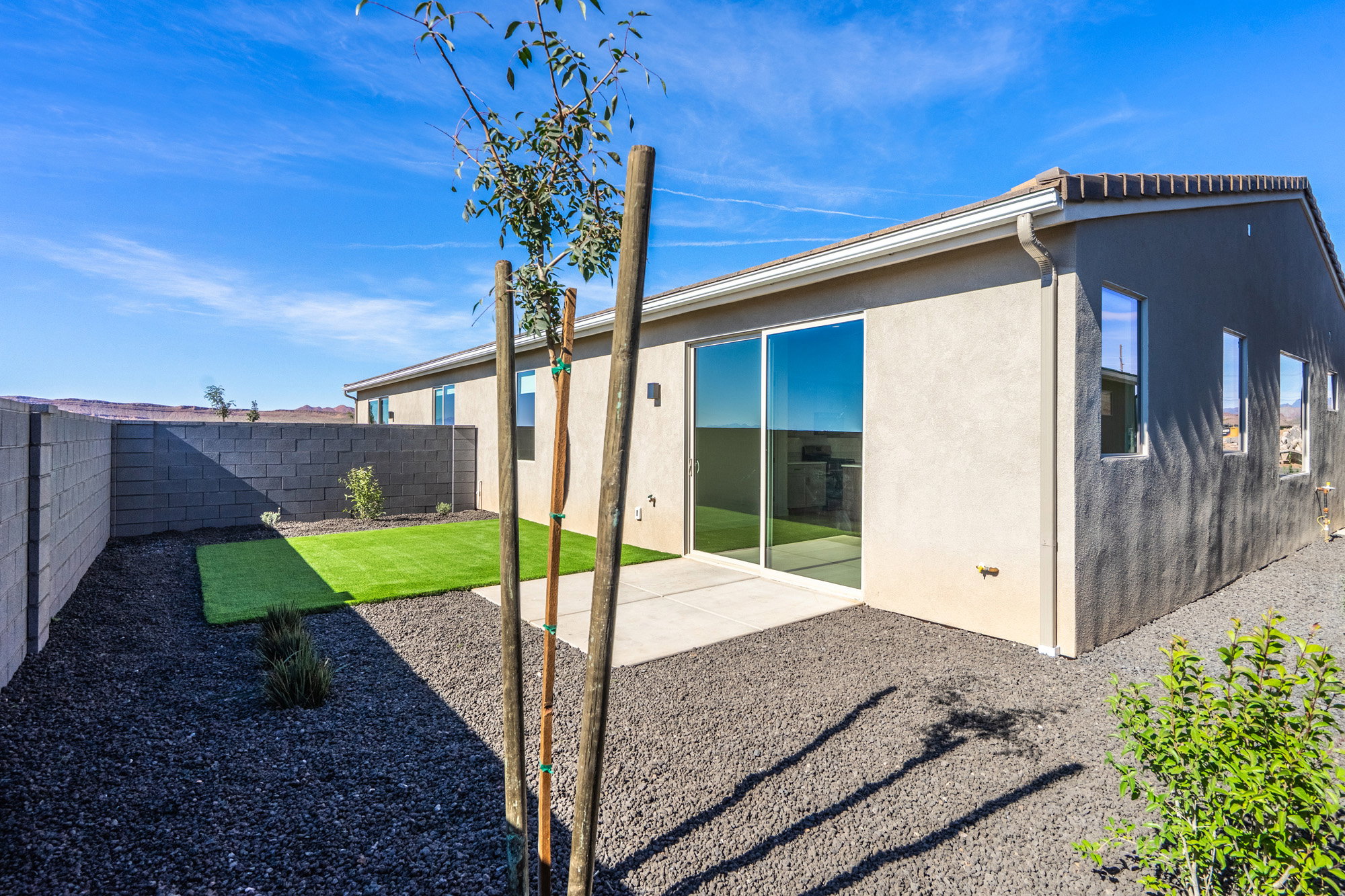 Back of property with stucco siding and a fenced backyard