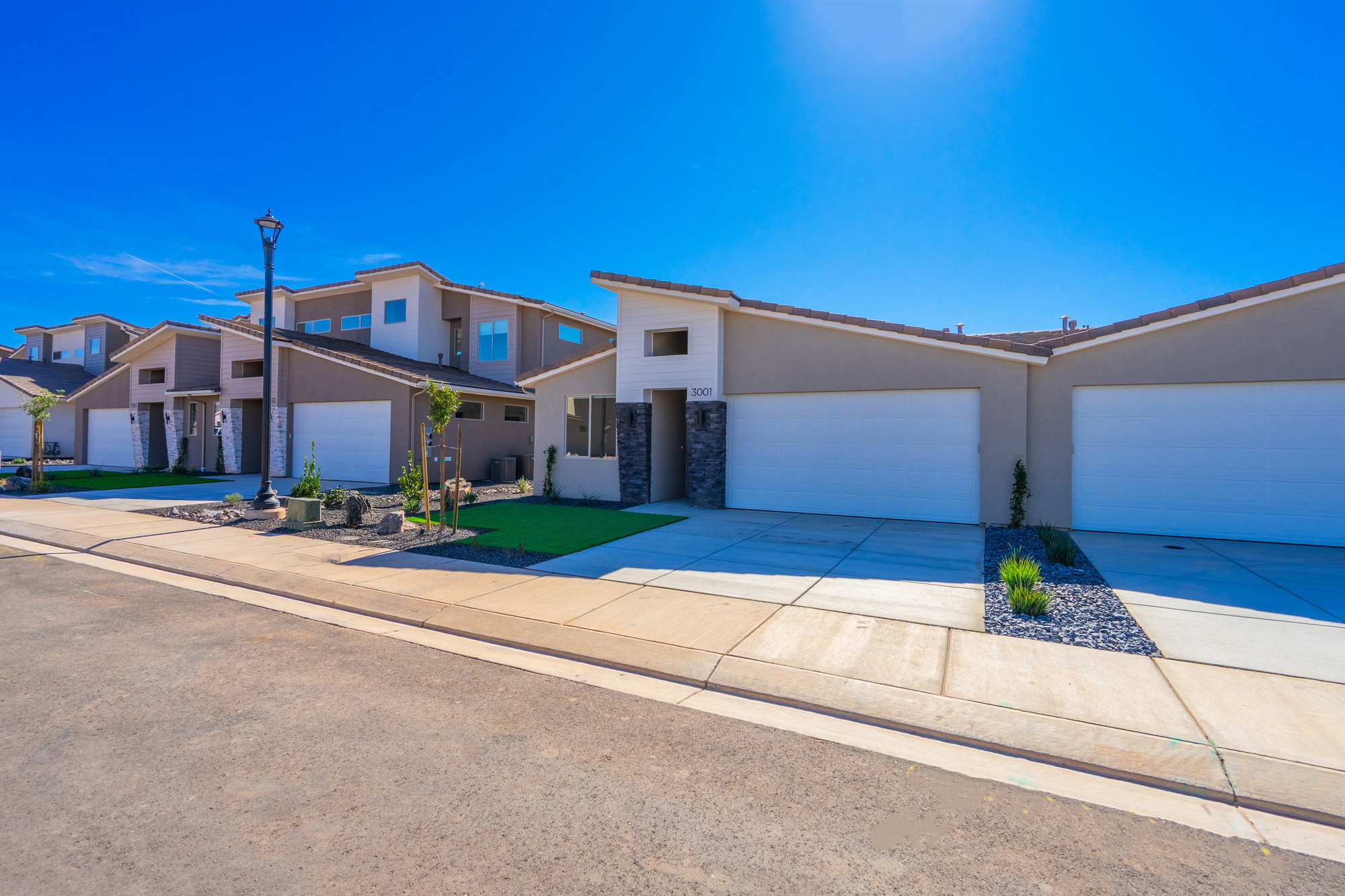 View of front of property with concrete driveway, stucco siding, an attached garage, and stone siding