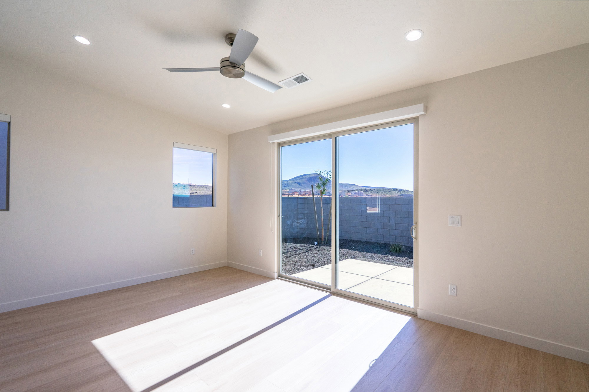 Unfurnished room with light wood-style floors, a ceiling fan, a mountain view, and recessed lighting