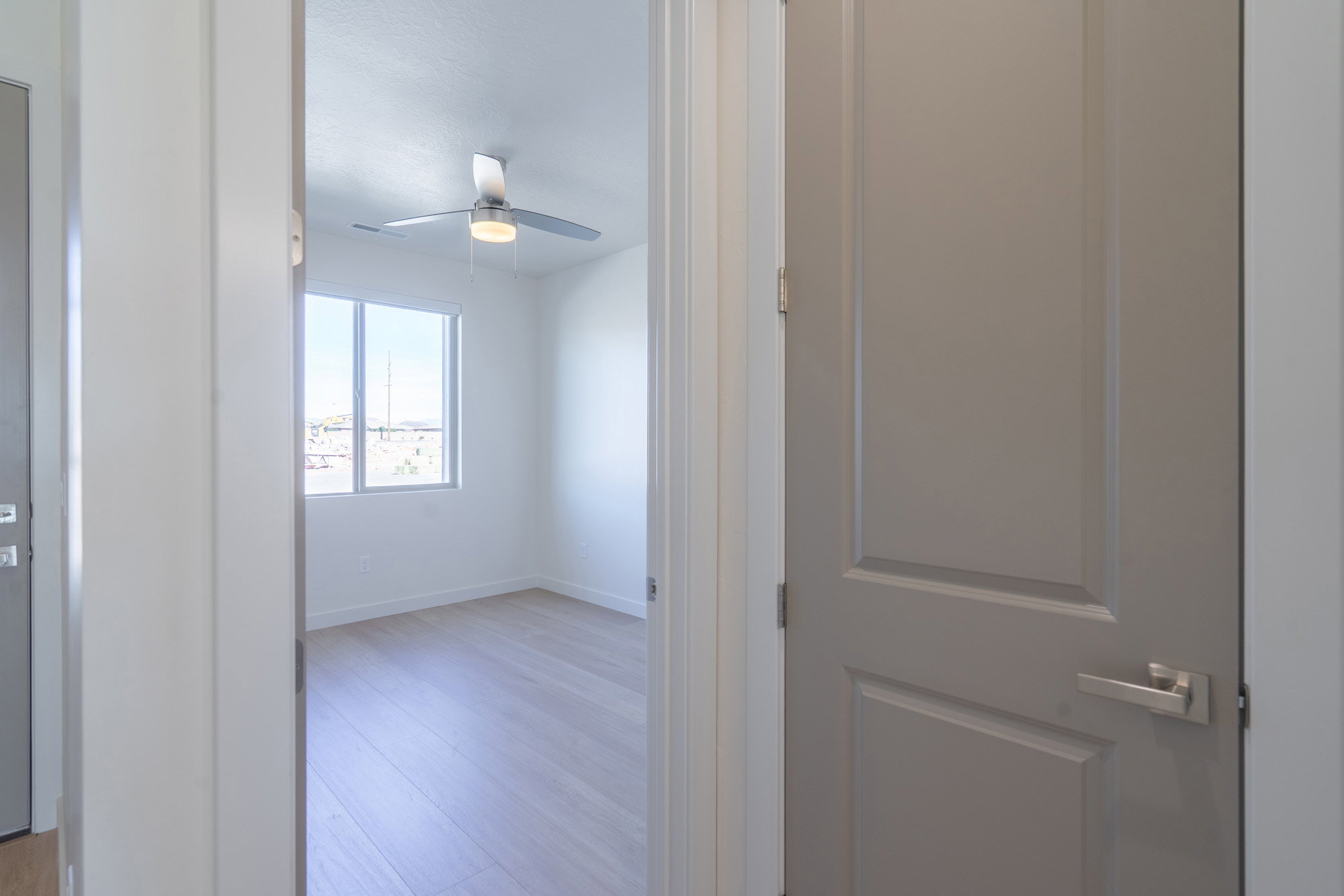 Corridor with light wood-style floors and baseboards