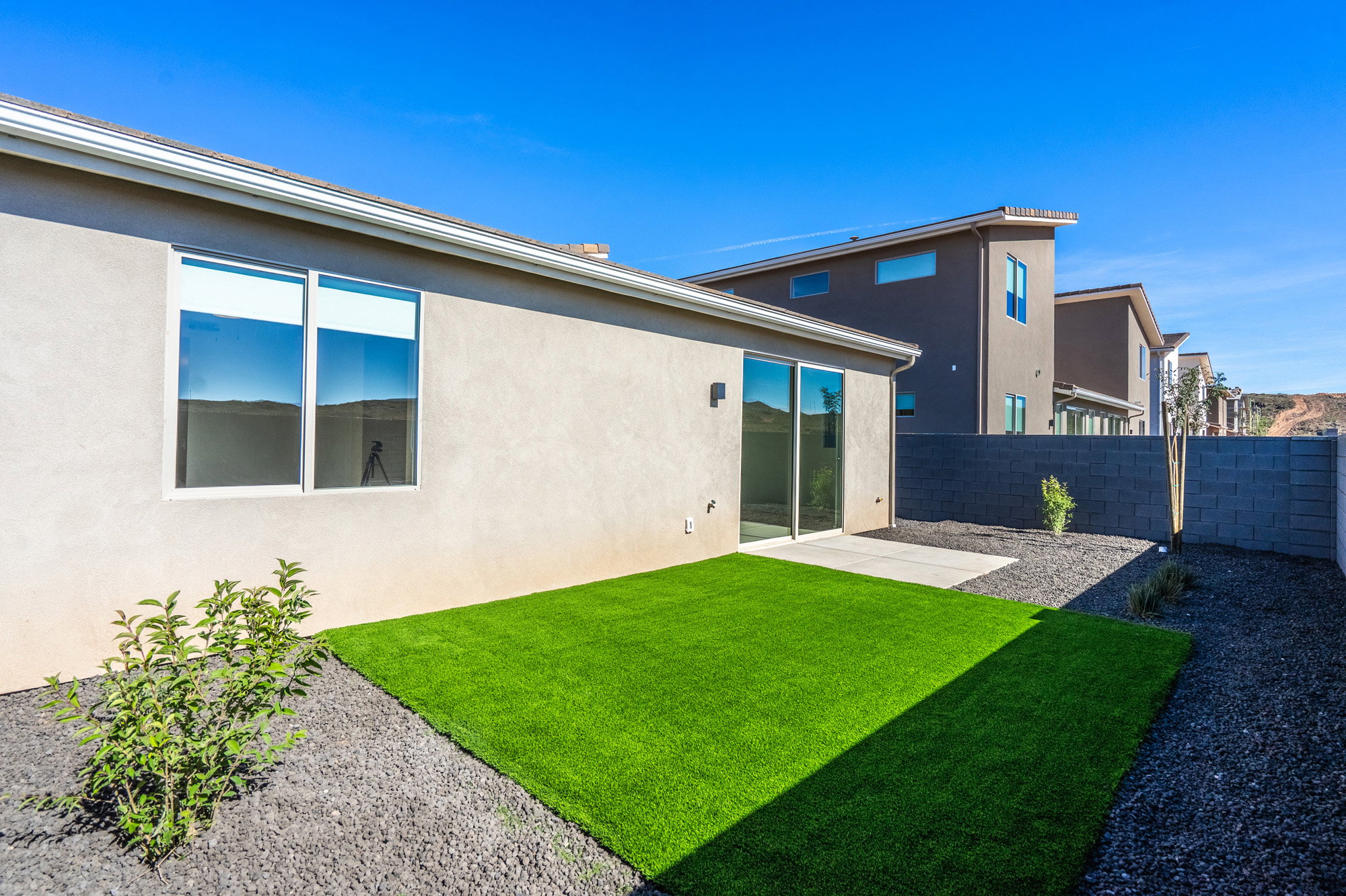 Back of house featuring a fenced backyard, stucco siding, and a patio