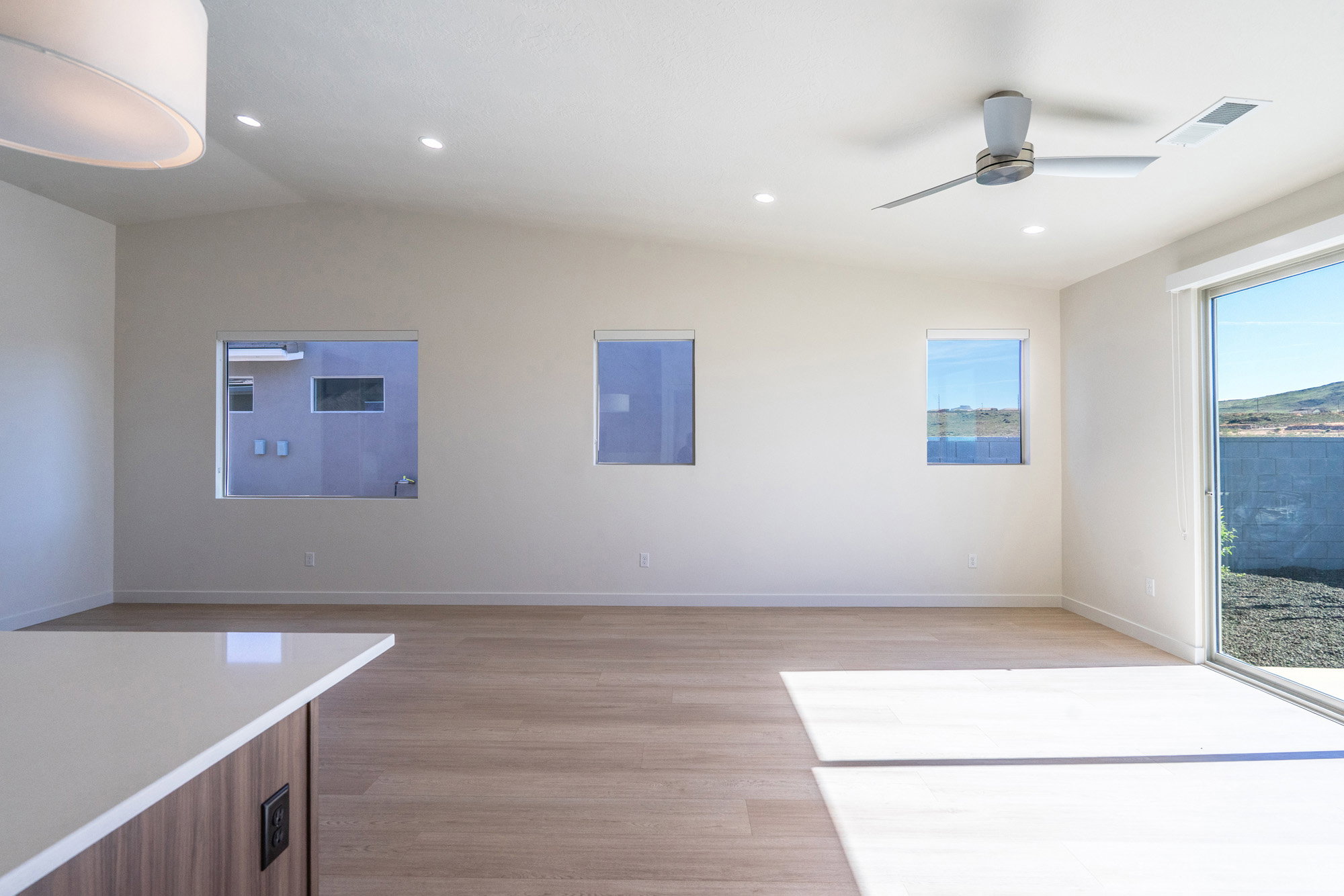 Unfurnished dining area with vaulted ceiling, light wood-style floors, ceiling fan, and recessed lighting