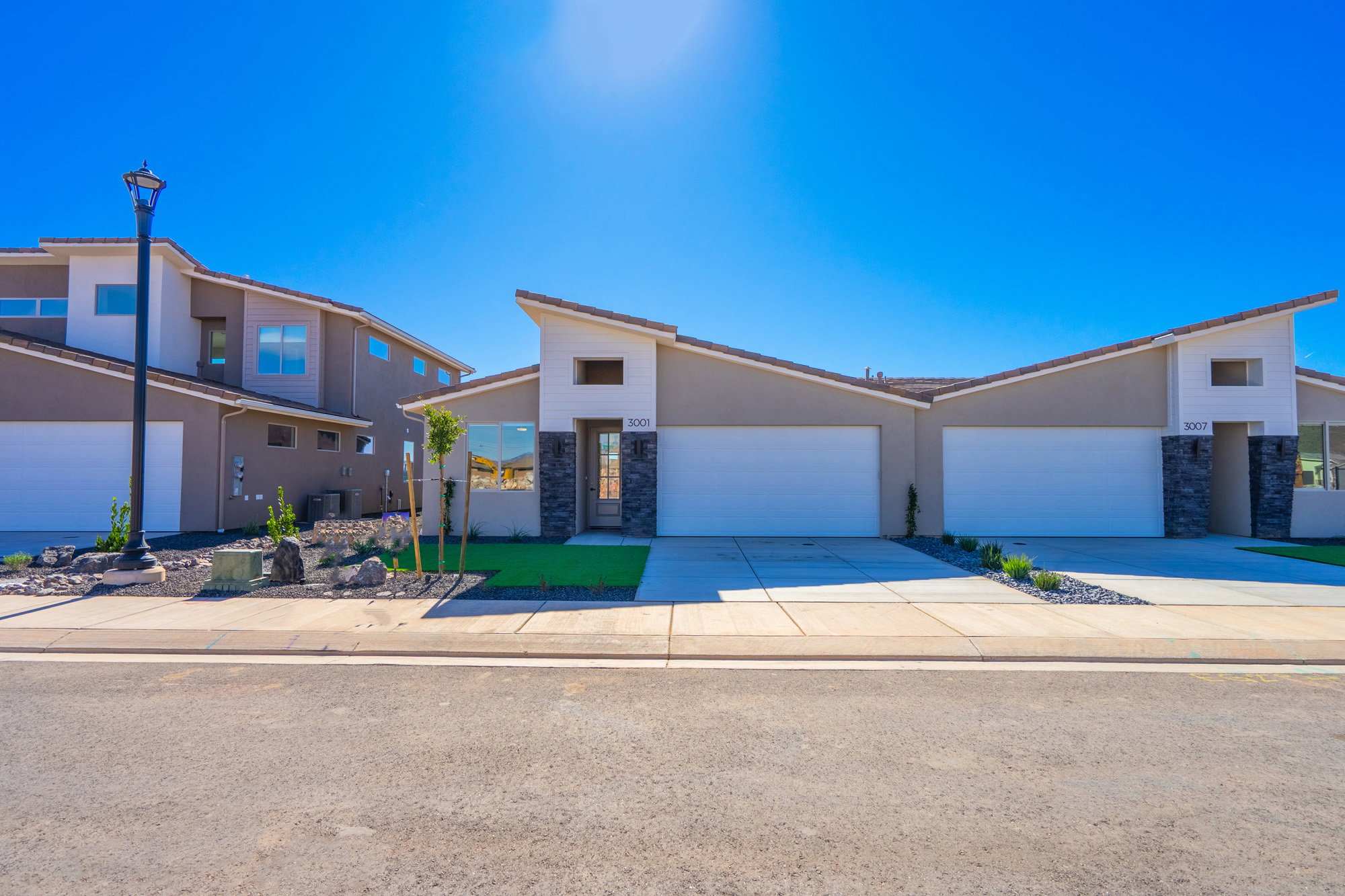 Mid-century home featuring stone siding, driveway, and a garage