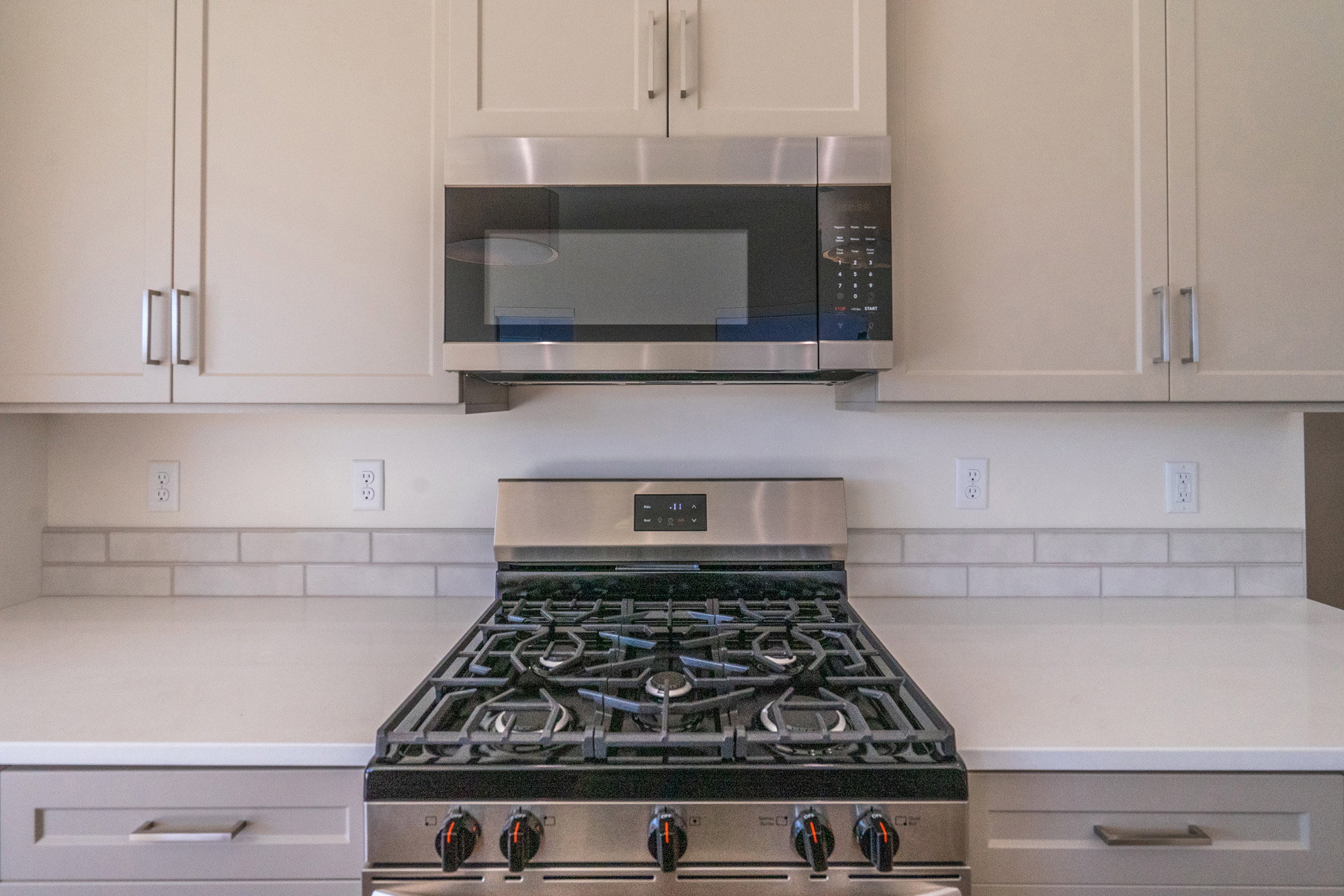 Kitchen with stainless steel appliances and light stone countertops