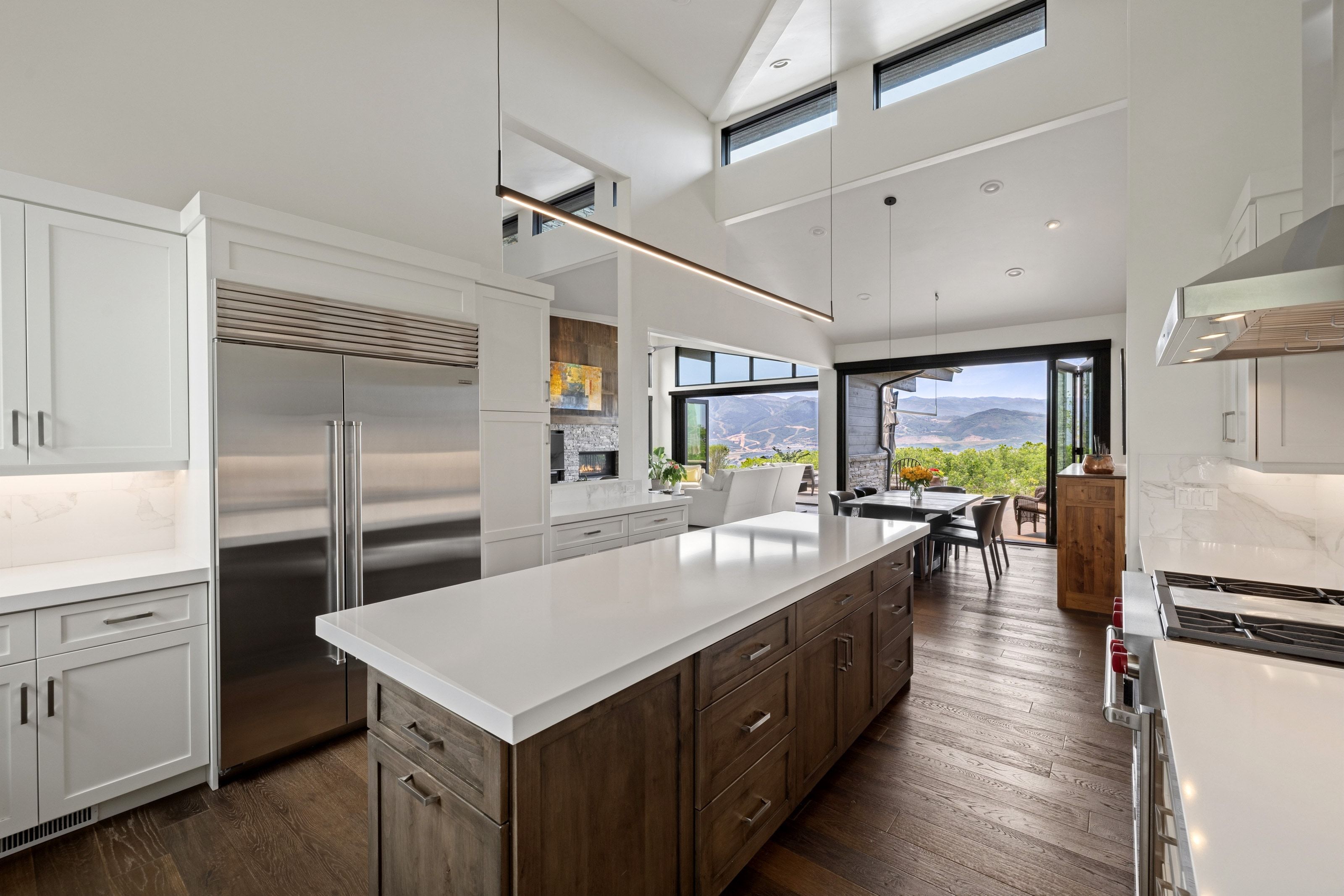 Gourmet kitchen with a large central island, light cabinetry, and stainless steel appliances