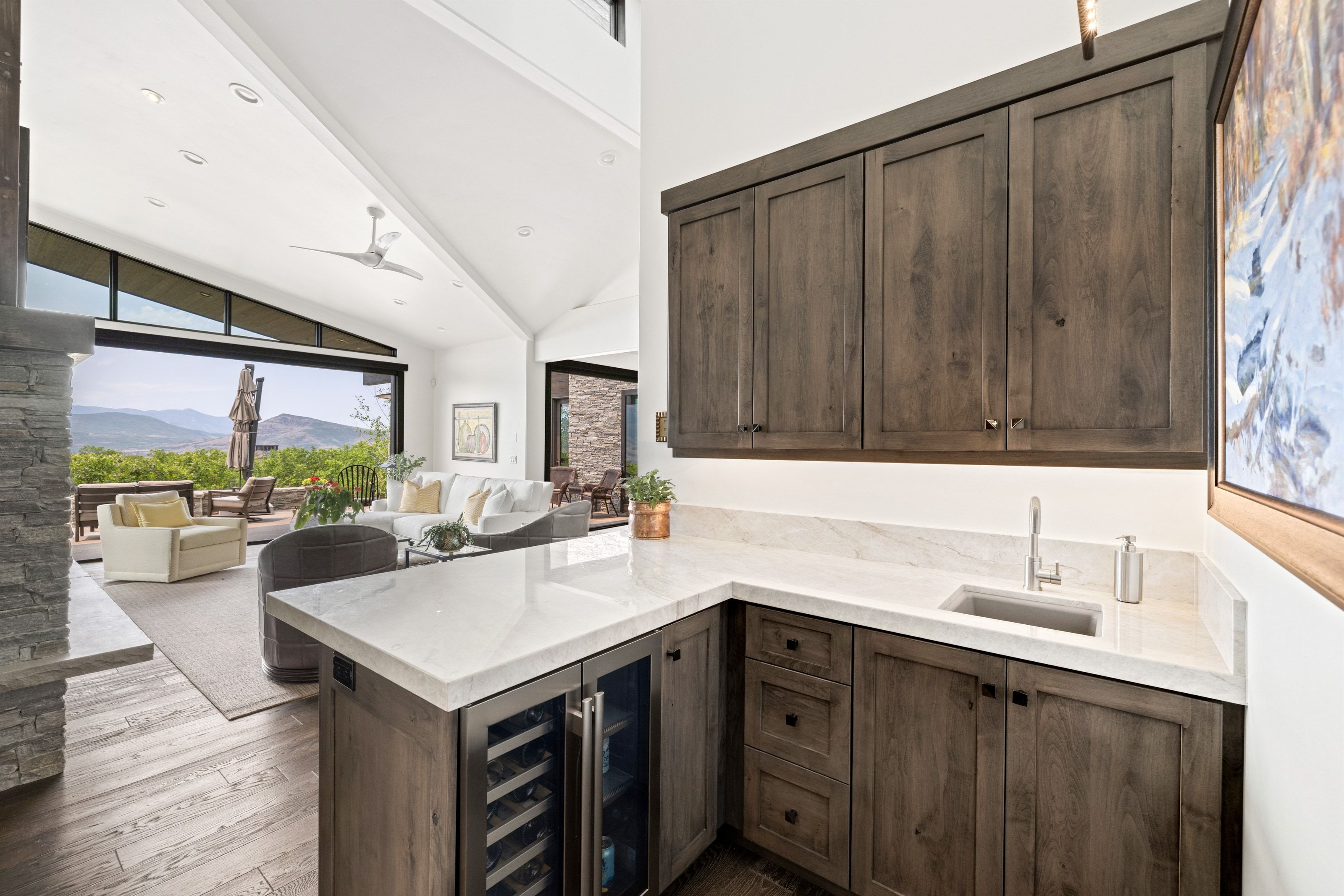 Wet bar featuring wood-finish cabinetry, light-toned countertops, and an integrated sink