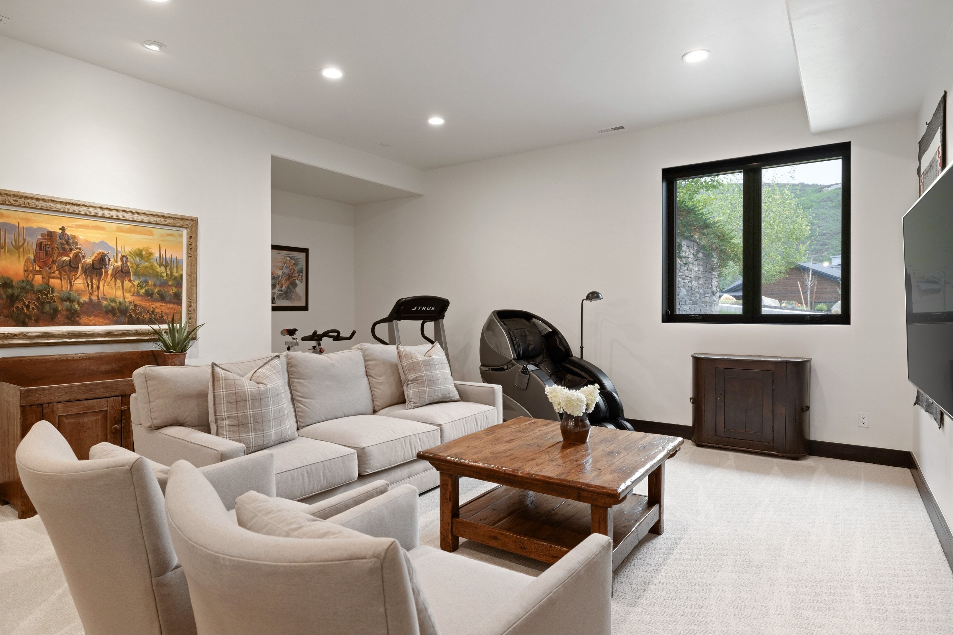 Spacious lower-level room featuring light-toned carpeting and recessed lighting