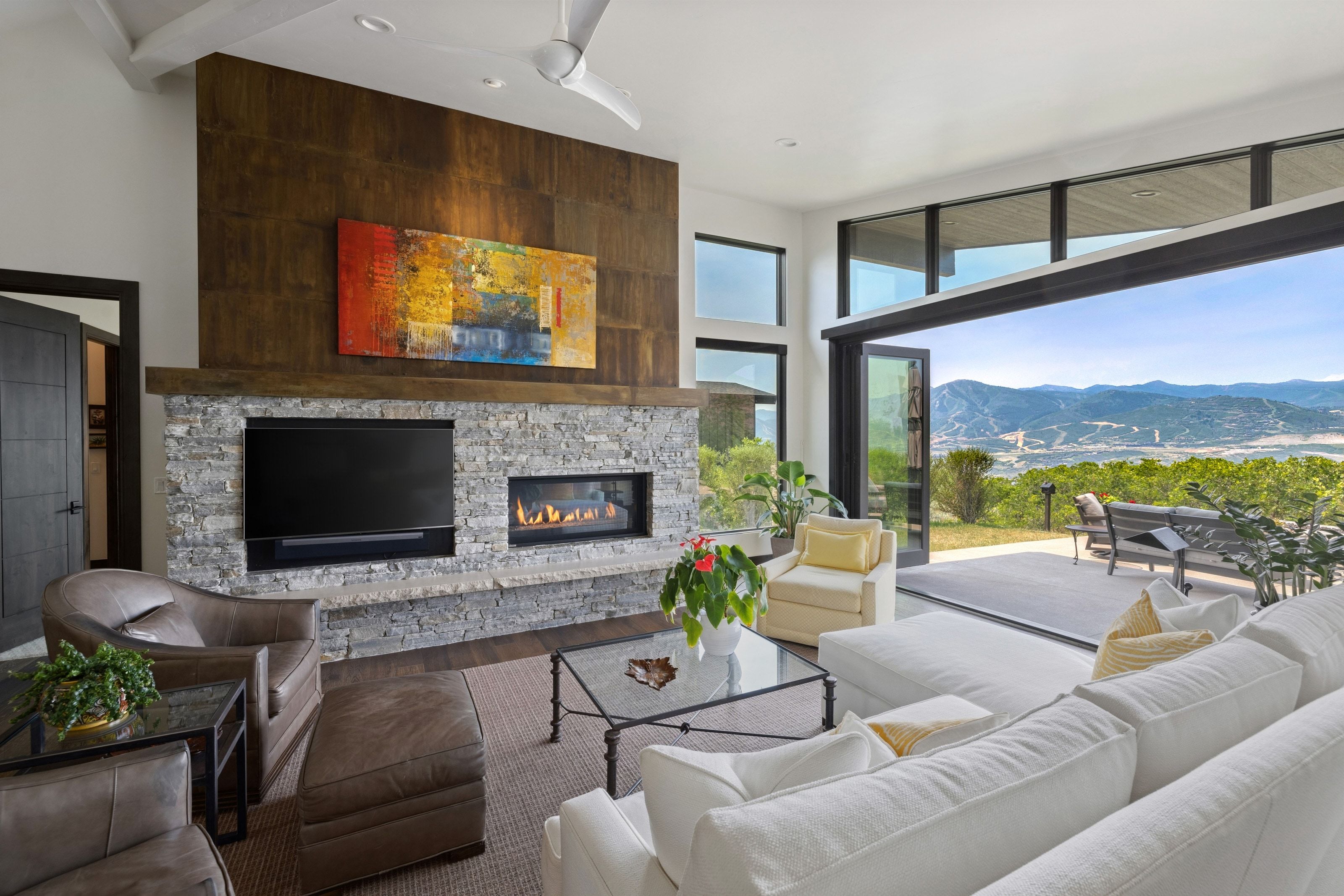 Expansive living area featuring a stacked stone fireplace with an integrated linear gas insert
